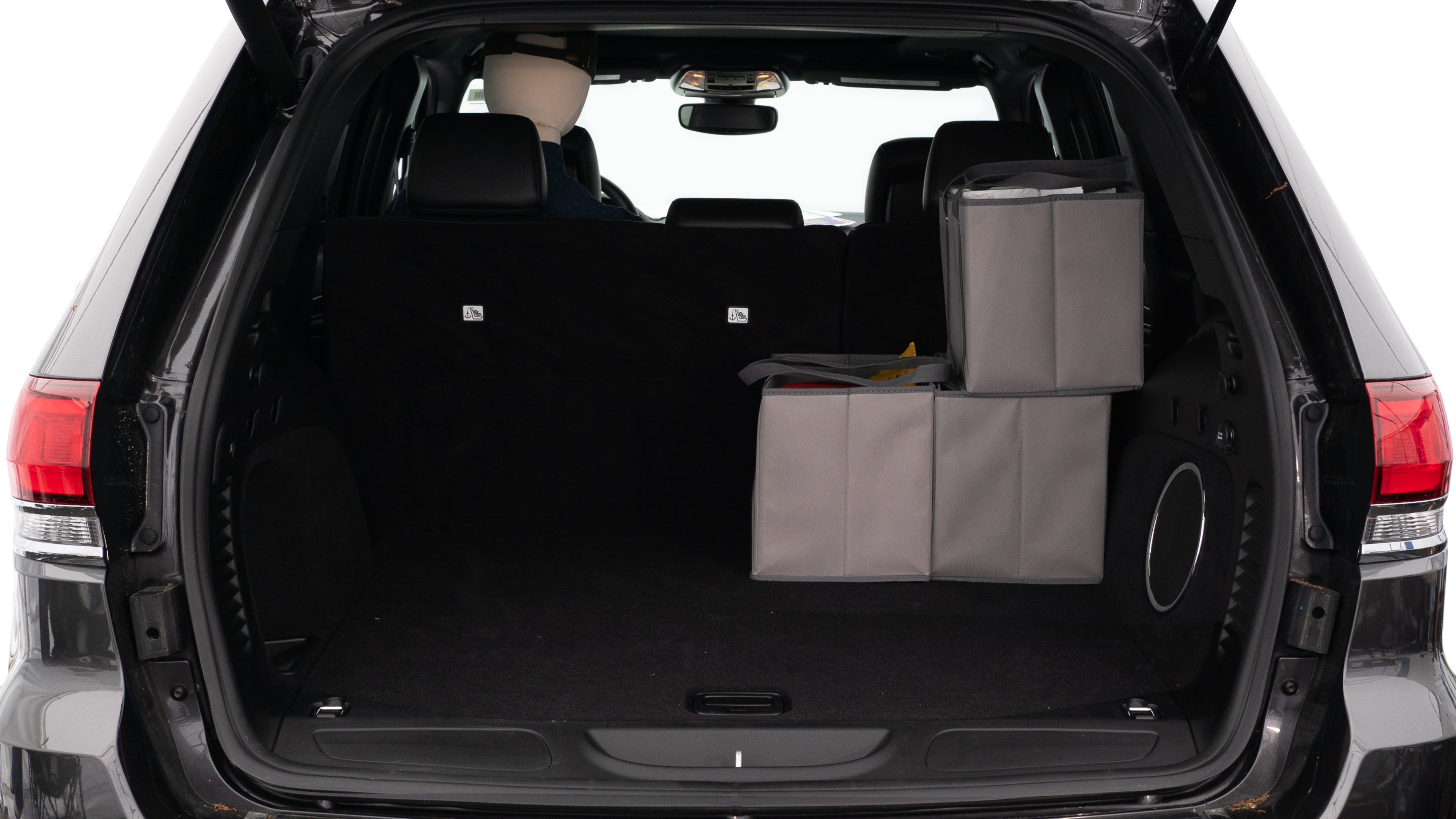 The trunk lid is open showing full view of the trunk. A baby stroller, three grocery carriers, two camping chairs in the carrying bag, and a set of golf clubs are placed inside.