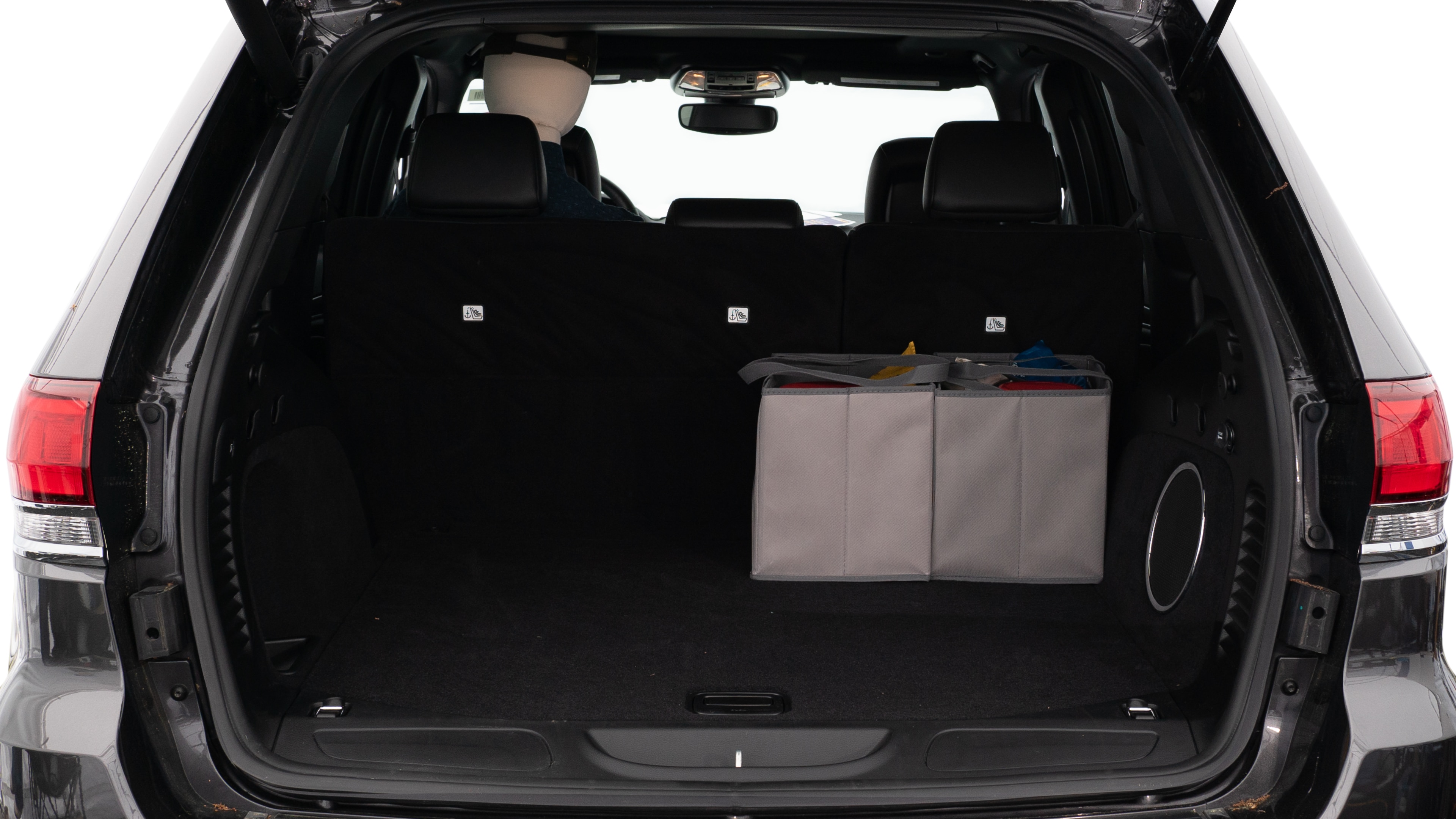 The trunk lid is open showing full view of the trunk. A baby stroller, three grocery carriers, two camping chairs in the carrying bag, and a set of golf clubs are placed inside.