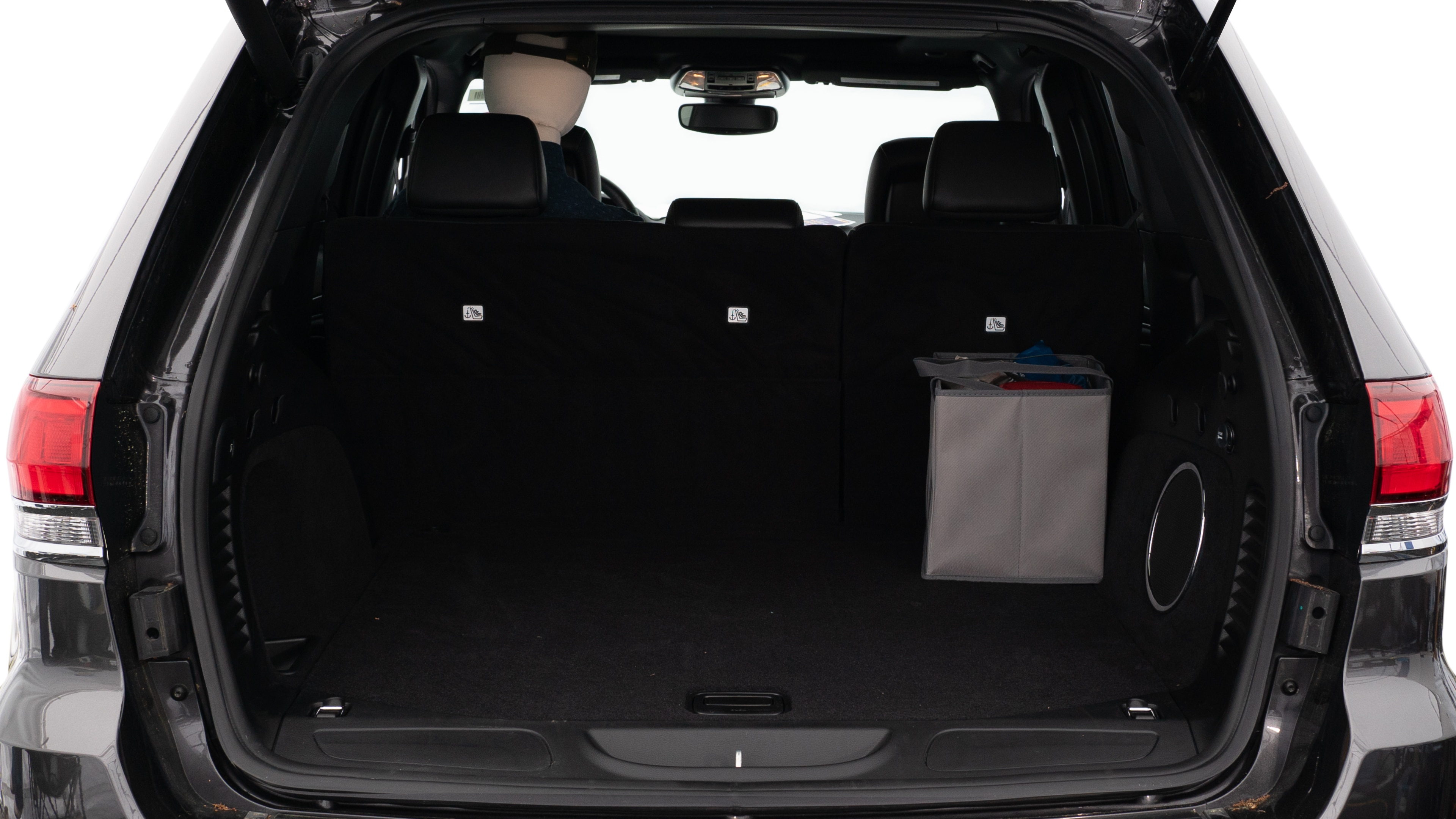 The trunk lid is open showing full view of the trunk. A baby stroller, three grocery carriers, two camping chairs in the carrying bag, and a set of golf clubs are placed inside.