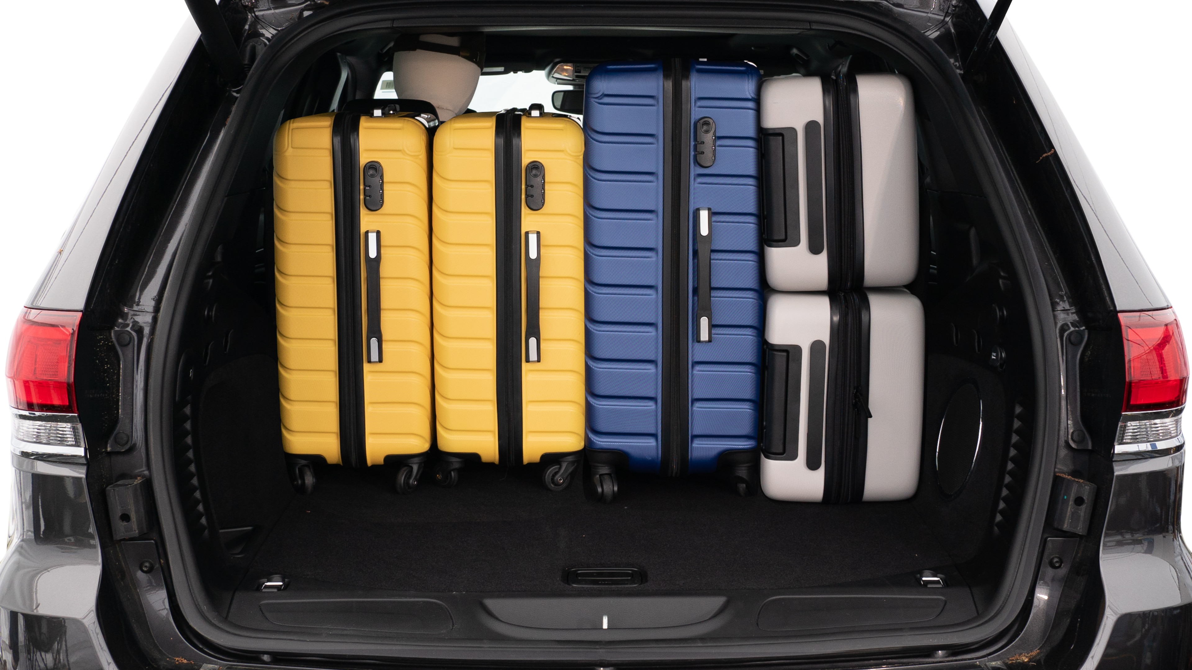 The trunk lid is open, showing a full view of the trunk space. Three large and two small suitcases are placed on there side