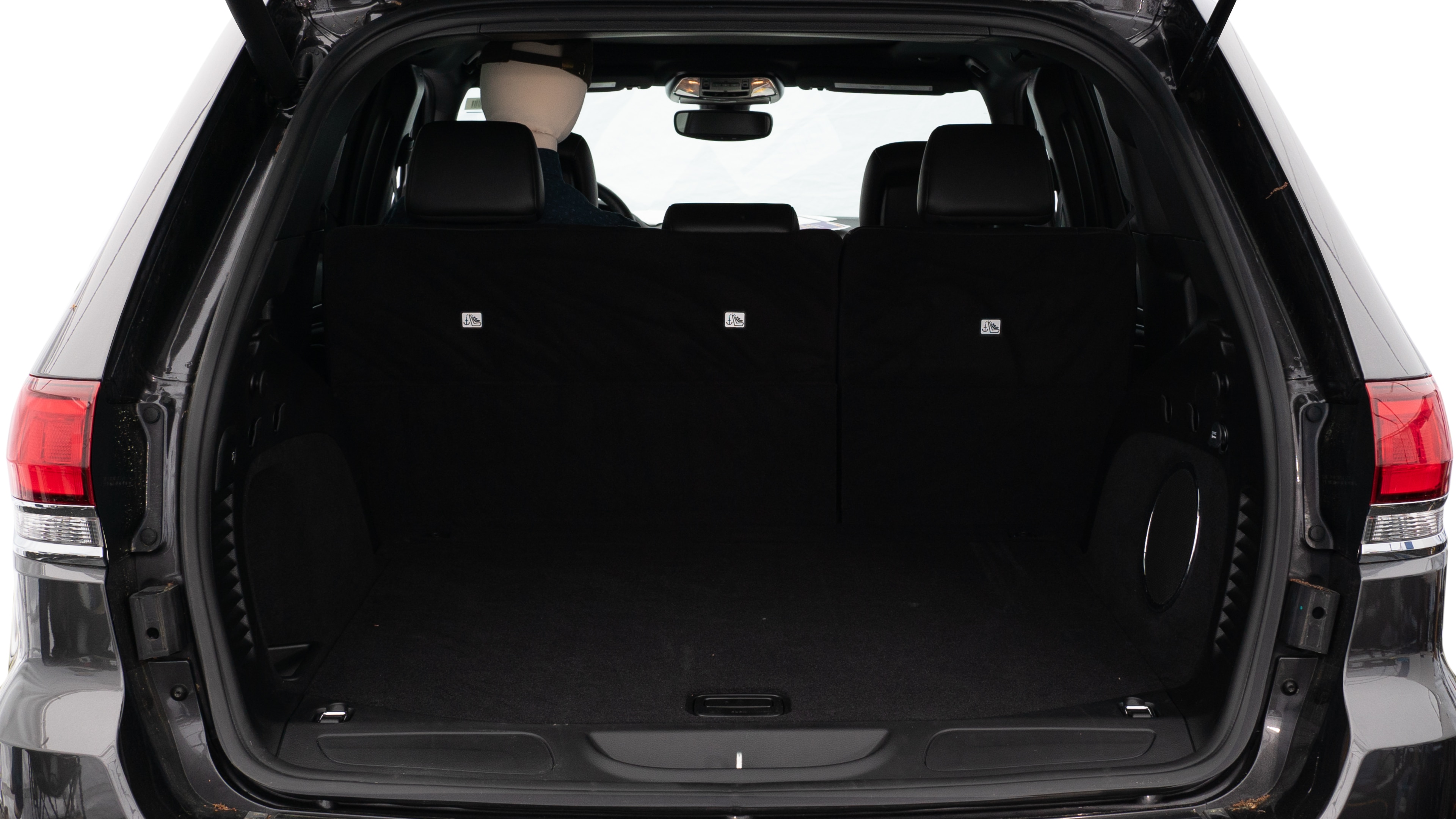 The trunk lid is open, showing a full view of the trunk space. Three large and two small suitcases are placed on there side