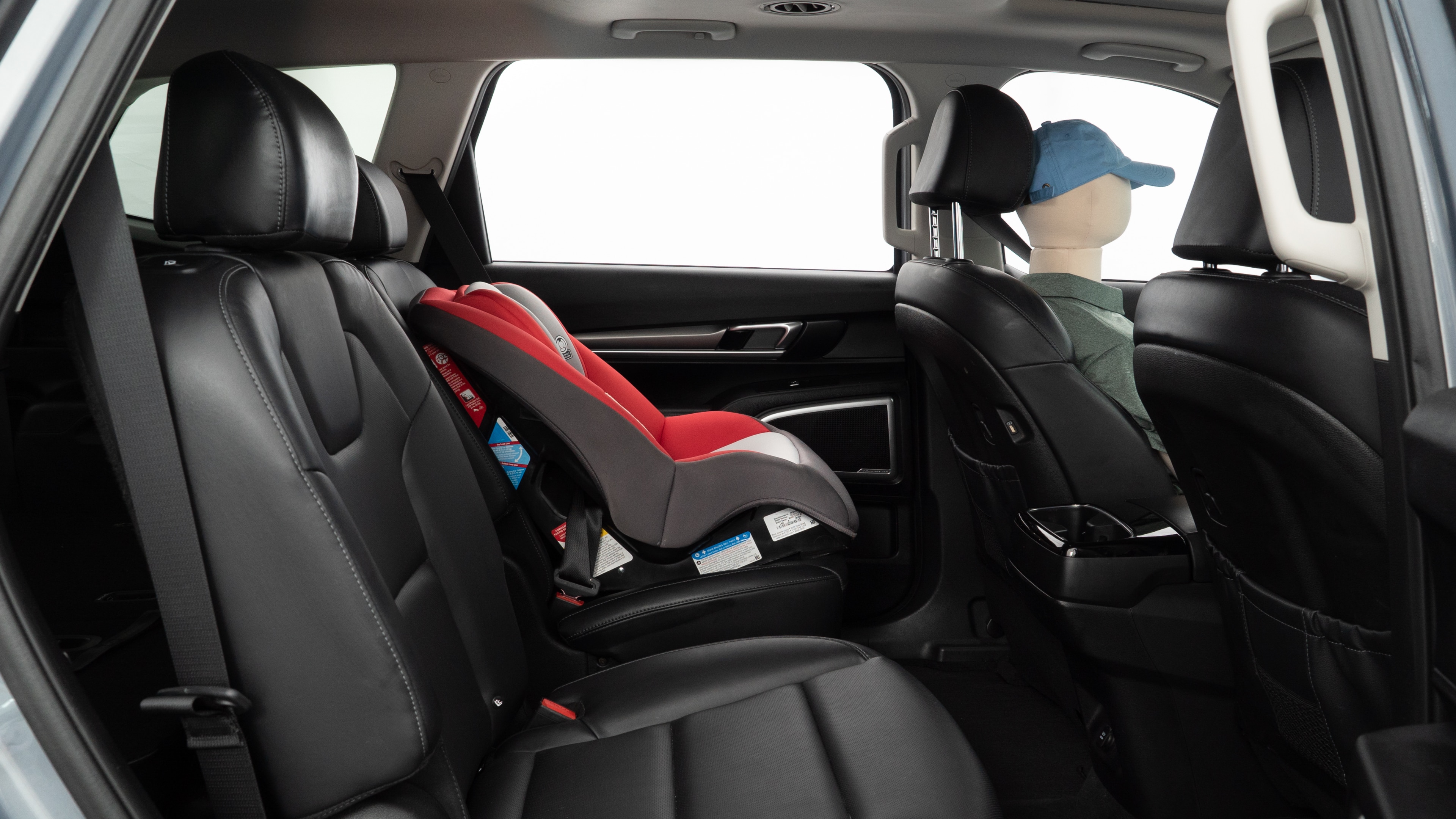 A series of second-row backseat photos is shown including one seating a baby seat and one seating a 6'1" mannequin.
