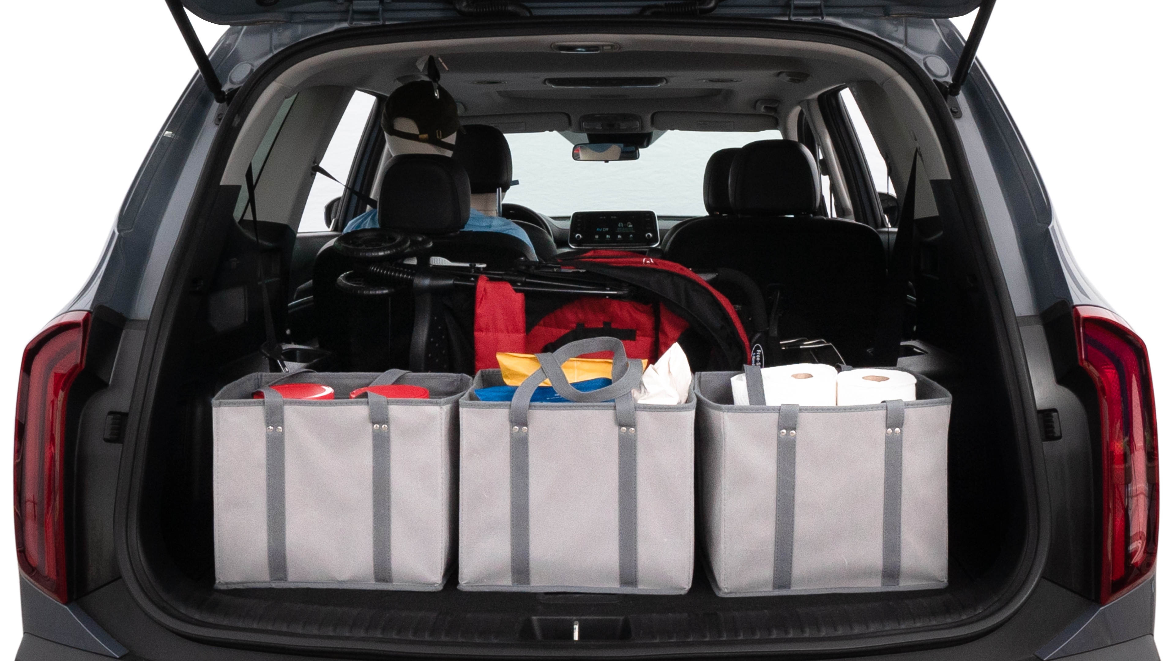 The trunk lid is open showing full view of the trunk. A baby stroller, three grocery carriers, two camping chairs in the carrying bag, and a set of golf clubs are placed inside.