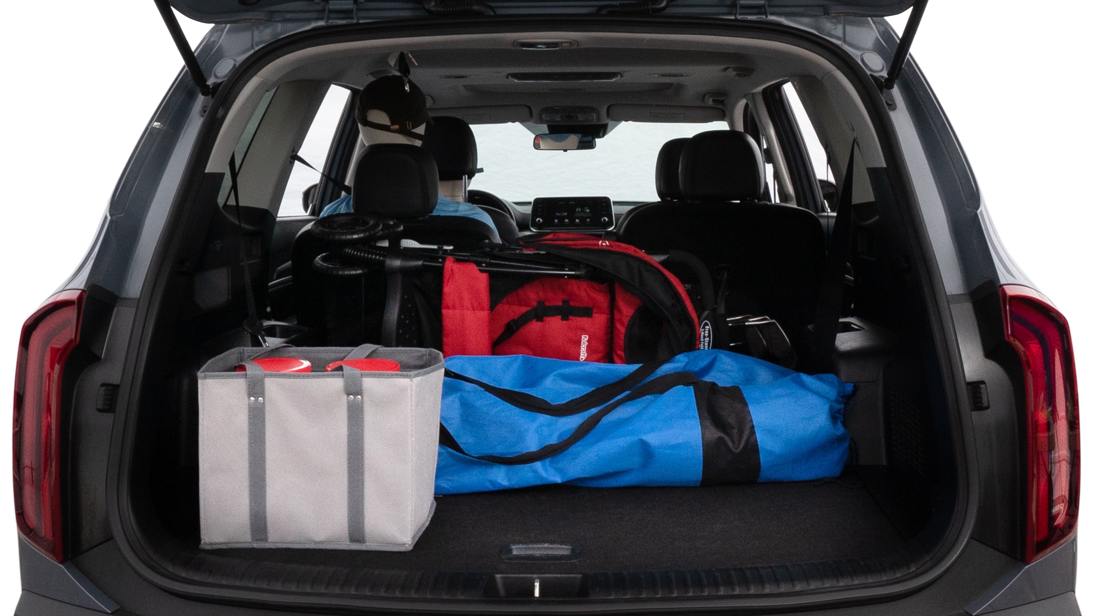 The trunk lid is open showing full view of the trunk. A baby stroller, three grocery carriers, two camping chairs in the carrying bag, and a set of golf clubs are placed inside.