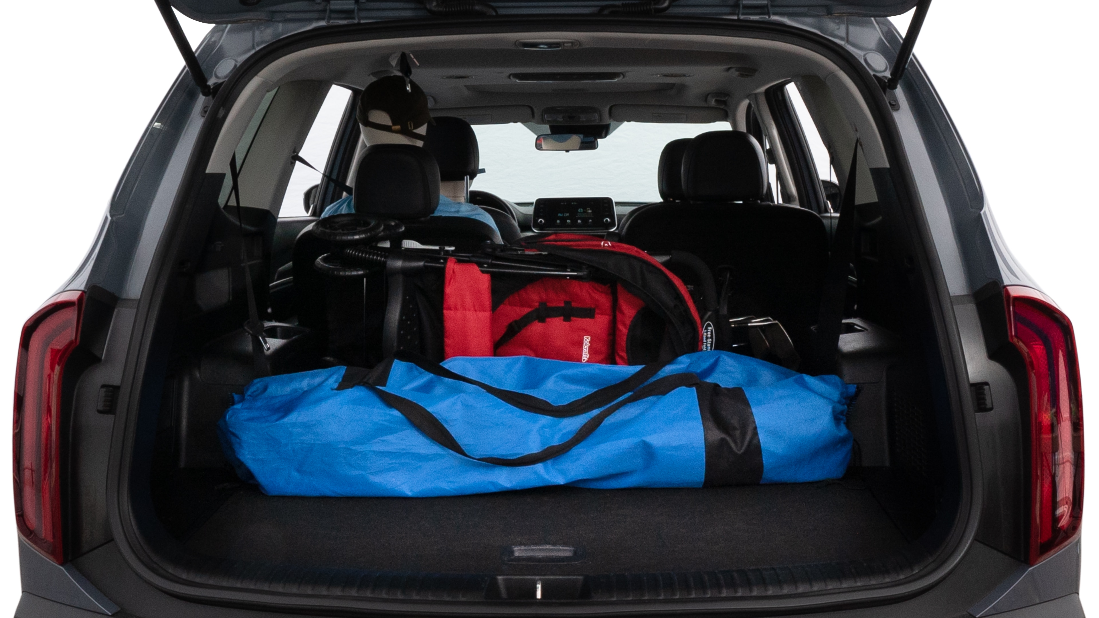 The trunk lid is open showing full view of the trunk. A baby stroller, three grocery carriers, two camping chairs in the carrying bag, and a set of golf clubs are placed inside.