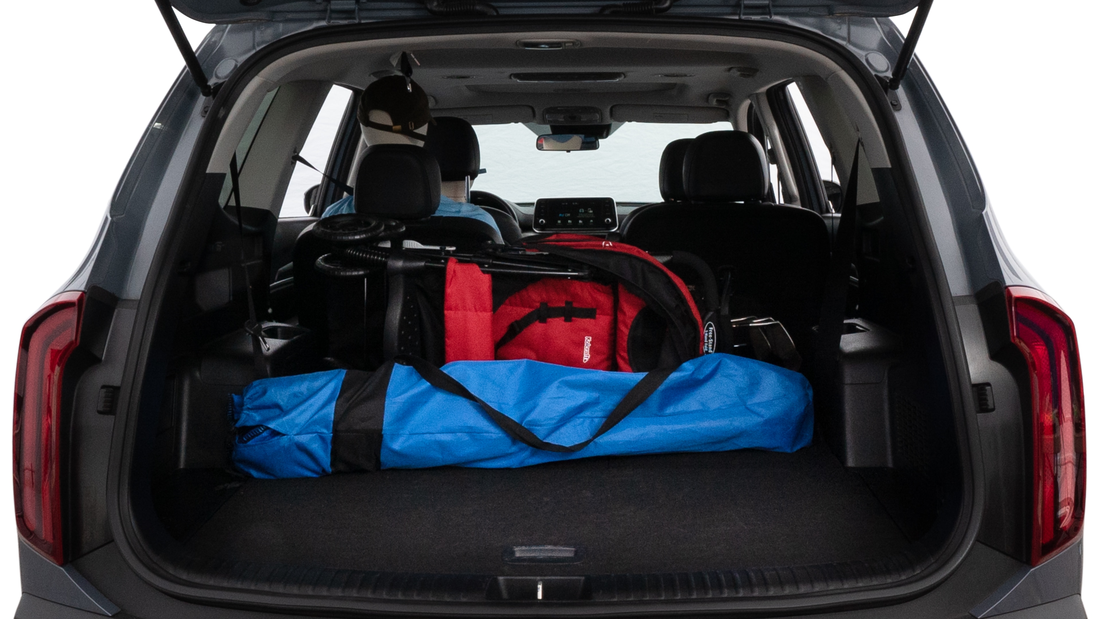 The trunk lid is open showing full view of the trunk. A baby stroller, three grocery carriers, two camping chairs in the carrying bag, and a set of golf clubs are placed inside.