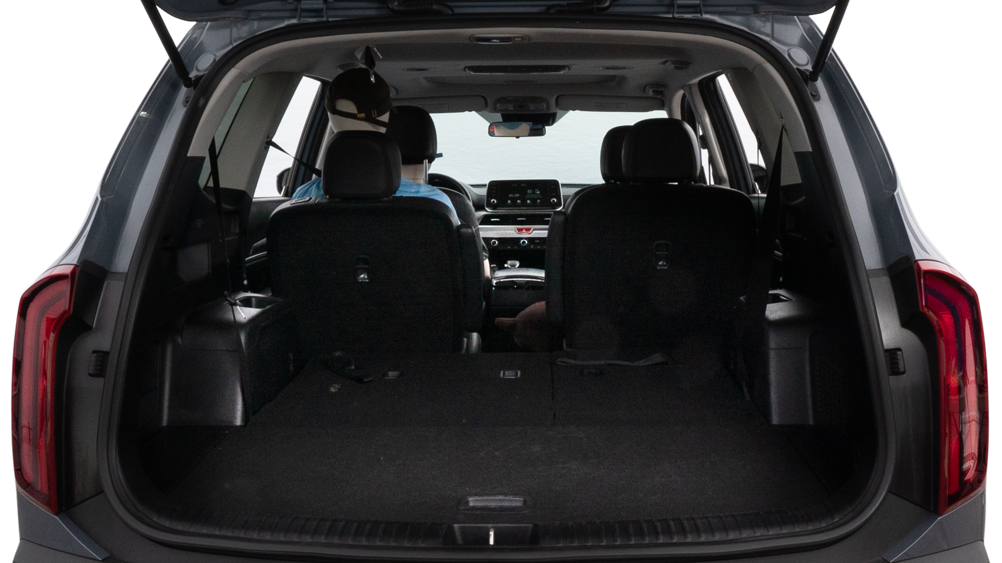 The trunk lid is open, showing full view of the trunk space. One large suitcase, two medium suitcases, and two small suitcases are placed inside.