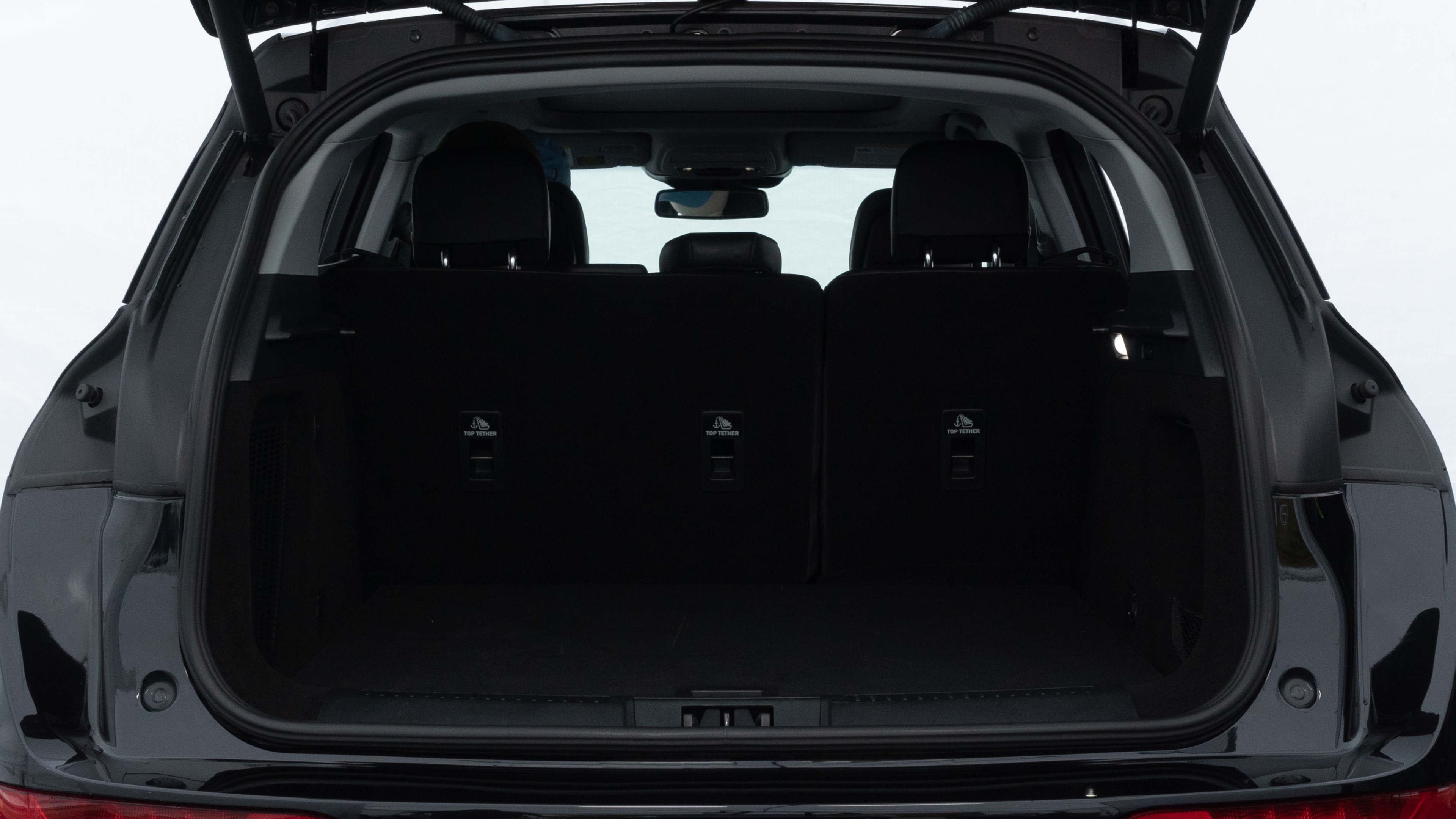 The trunk lid is open showing full view of the trunk. A baby stroller, three grocery carriers, two camping chairs in the carrying bag, and a set of golf clubs are placed inside.