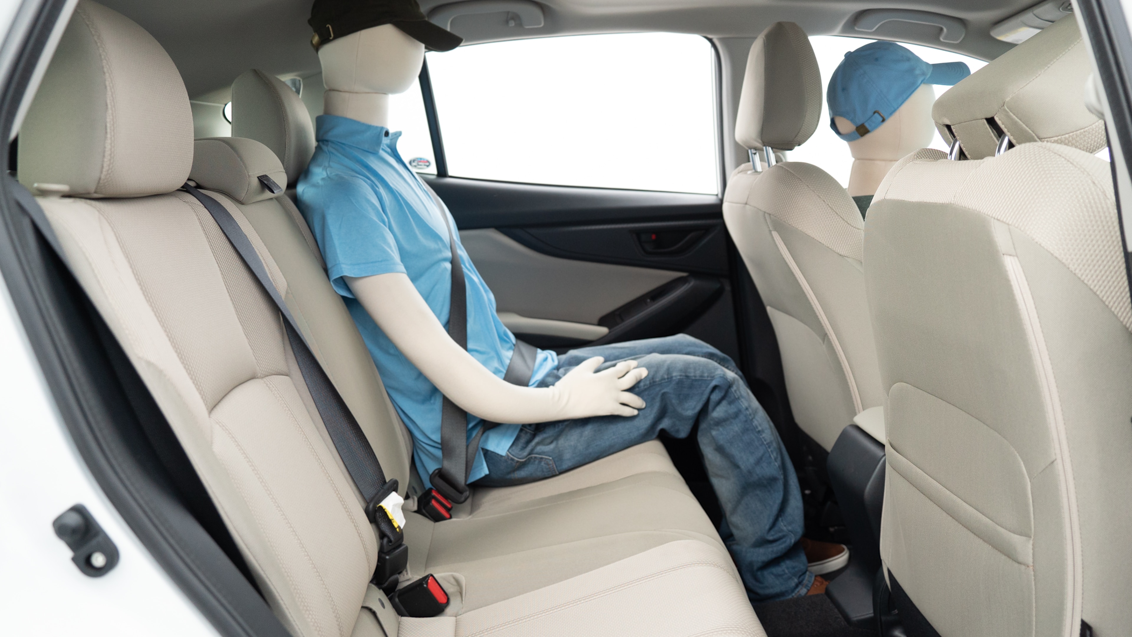 A series of second-row backseat photos is shown including one seating a baby seat, a dog and one seating a 6'1" mannequin.