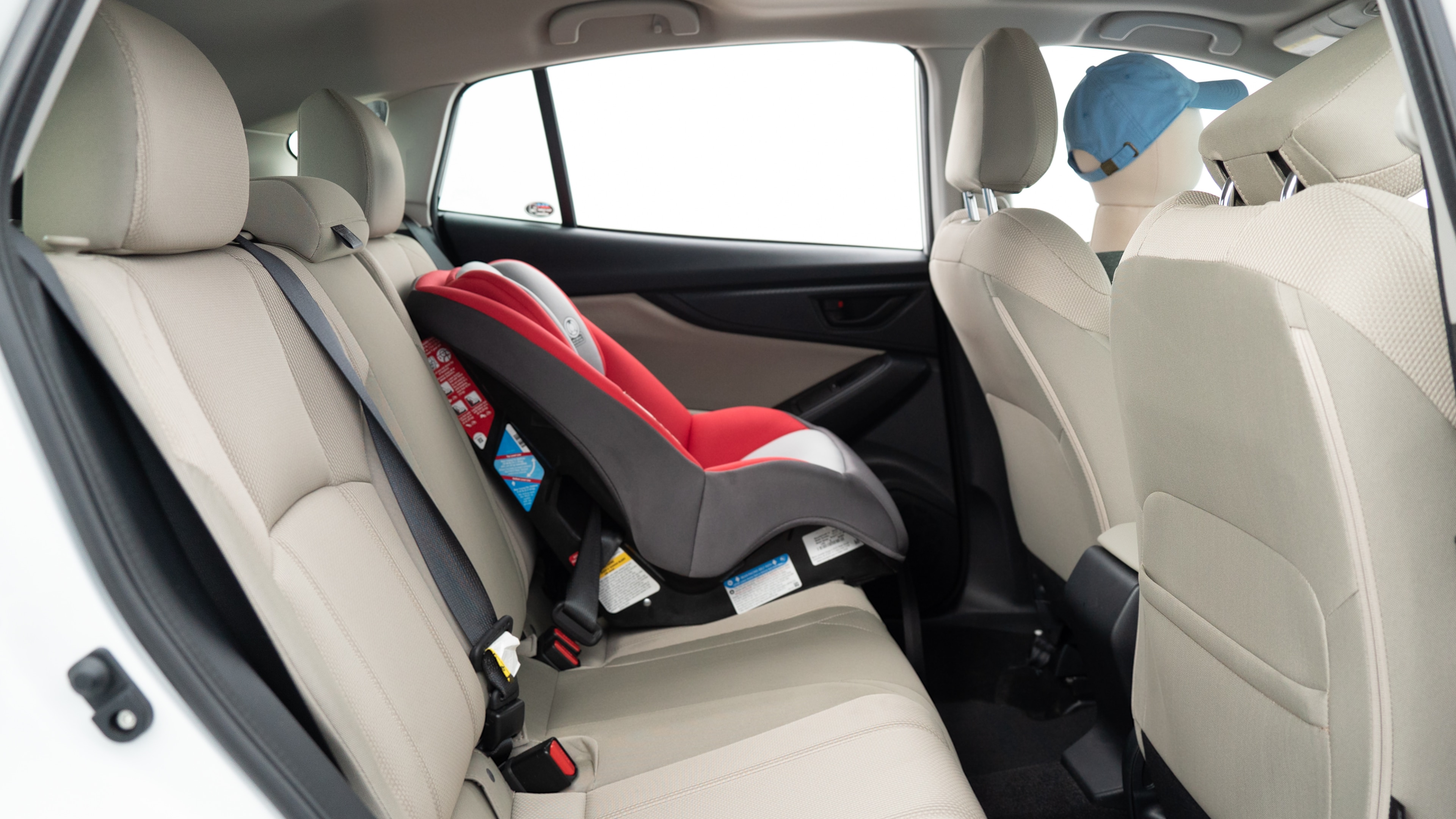 A series of second-row backseat photos is shown including one seating a baby seat, a dog and one seating a 6'1" mannequin.
