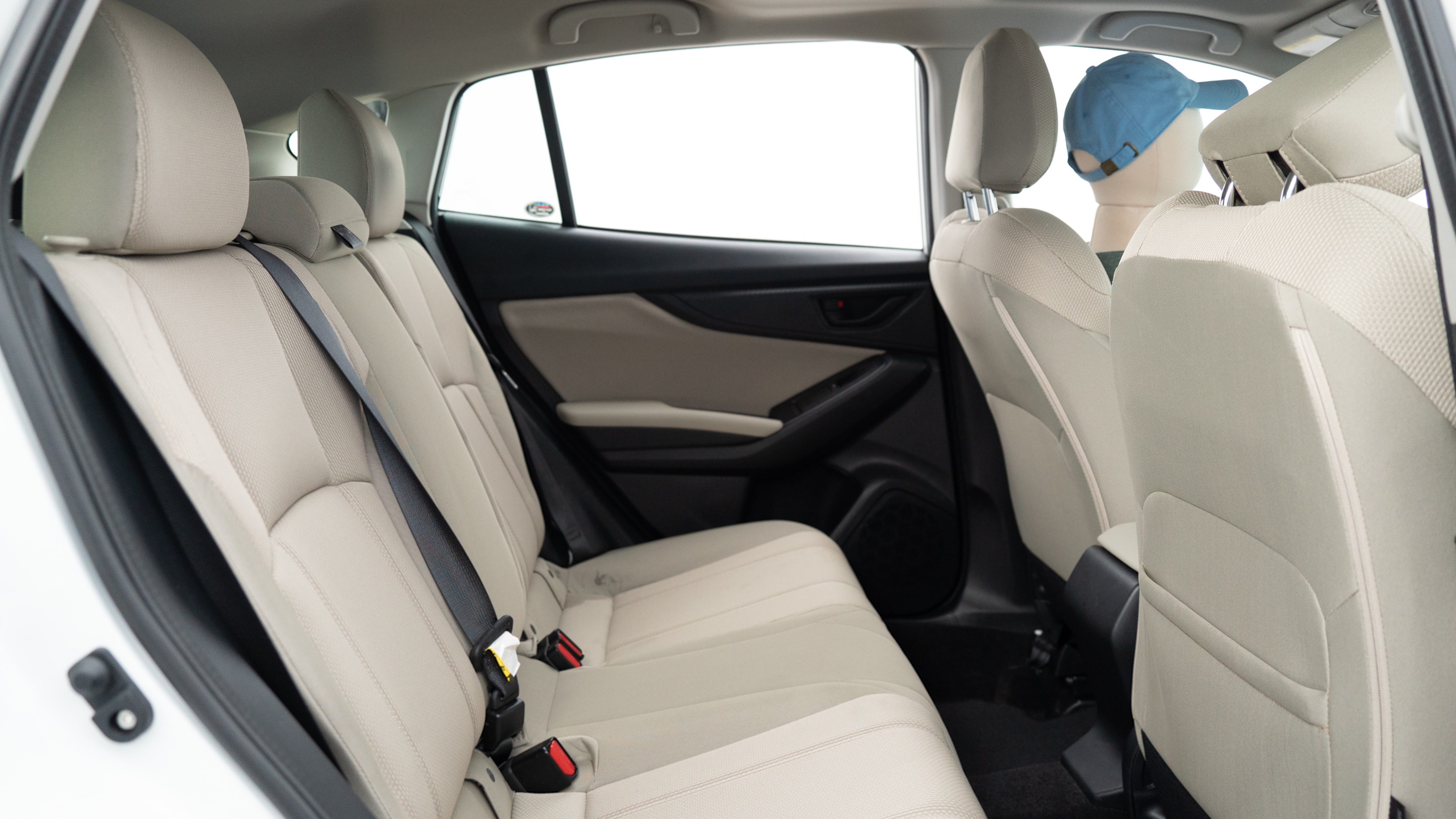 A series of second-row backseat photos is shown including one seating a baby seat, a dog and one seating a 6'1" mannequin.