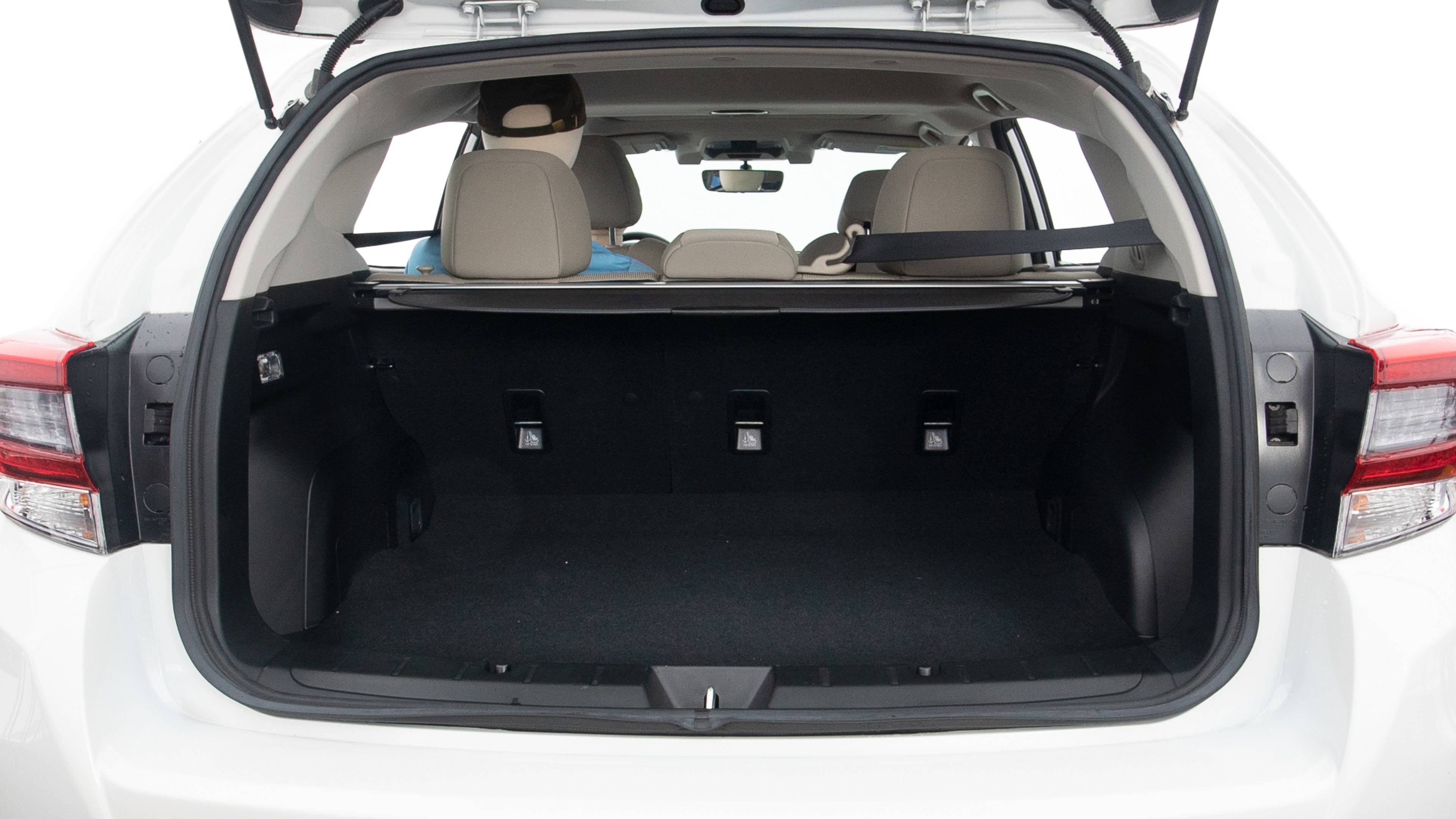 The trunk lid is open, showing full view of the trunk space. Two large and two small suitcases are placed inside.