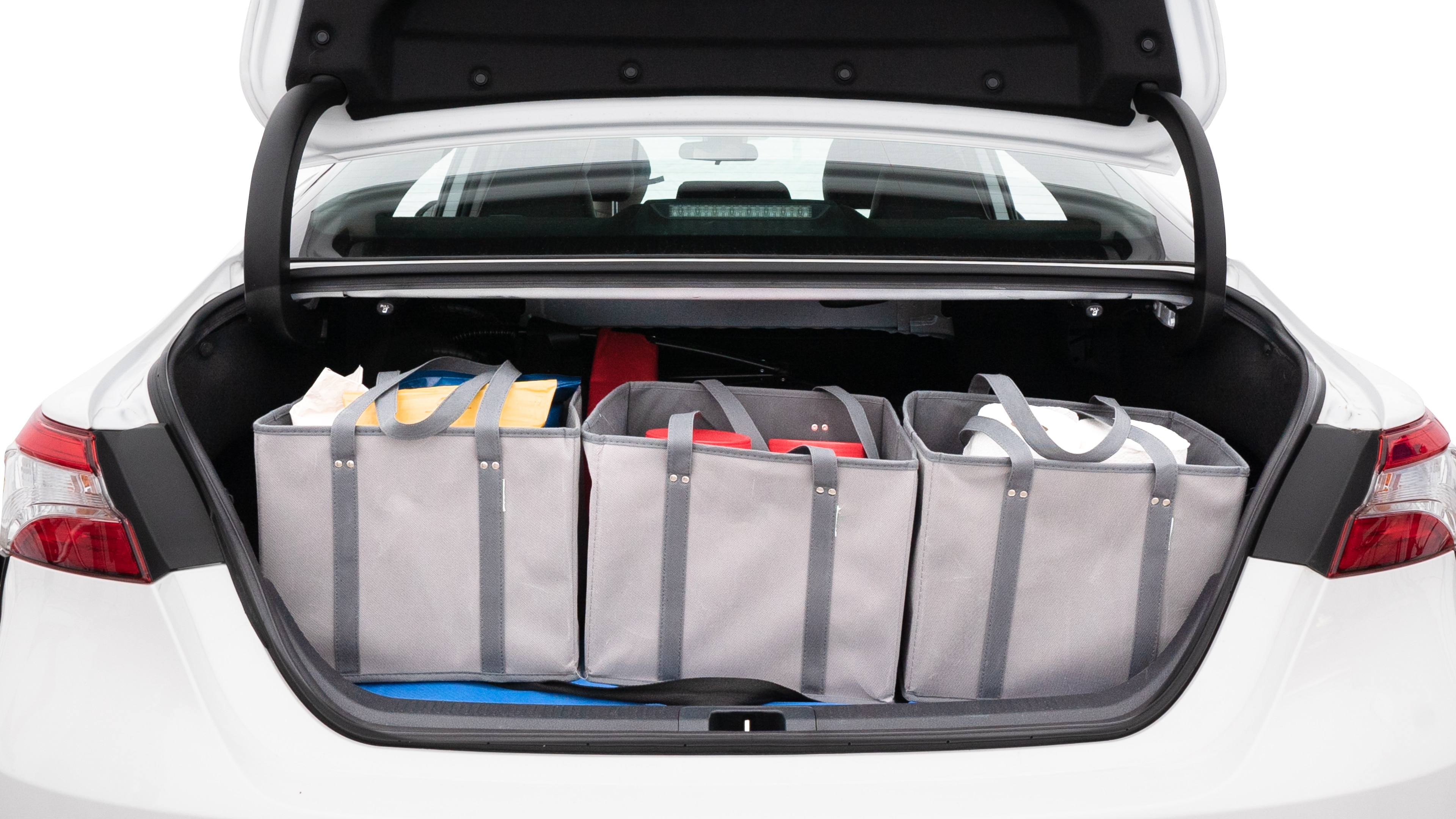 The trunk lid is open showing full view of the trunk. A baby stroller, three grocery carriers, two camping chairs in the carrying bag, and a set of golf clubs are placed inside.