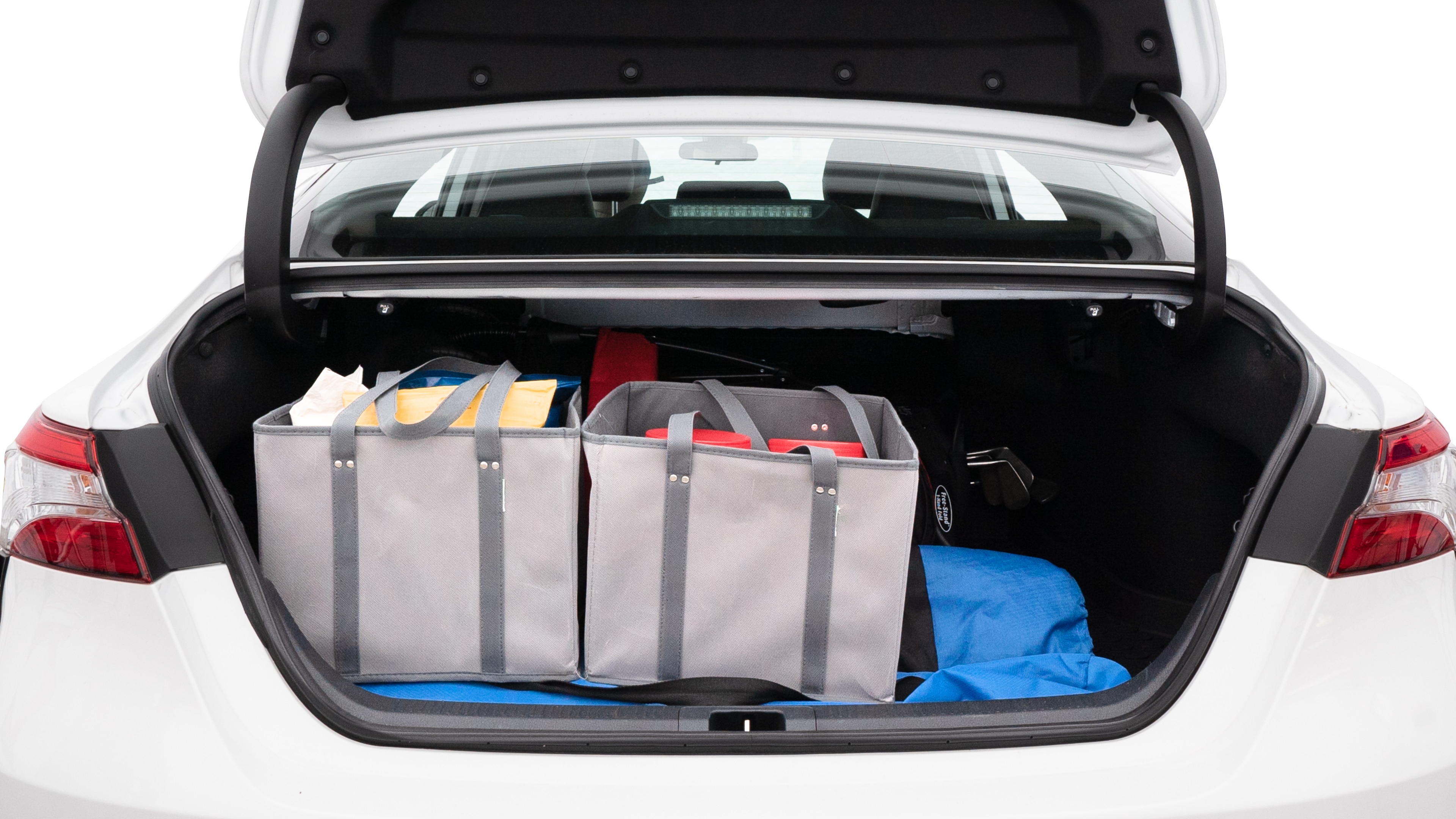 The trunk lid is open showing full view of the trunk. A baby stroller, three grocery carriers, two camping chairs in the carrying bag, and a set of golf clubs are placed inside.