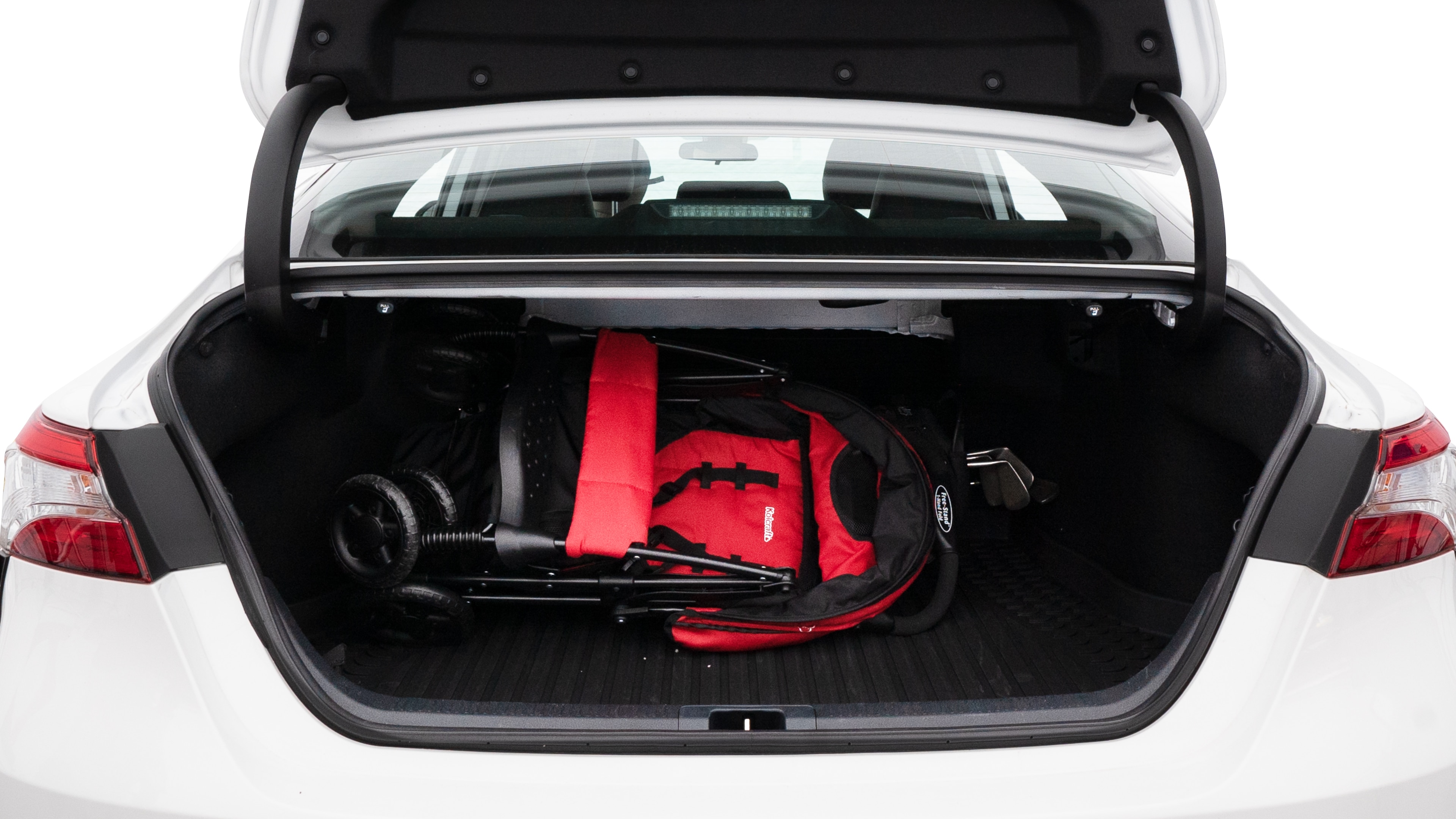 The trunk lid is open showing full view of the trunk. A baby stroller, three grocery carriers, two camping chairs in the carrying bag, and a set of golf clubs are placed inside.