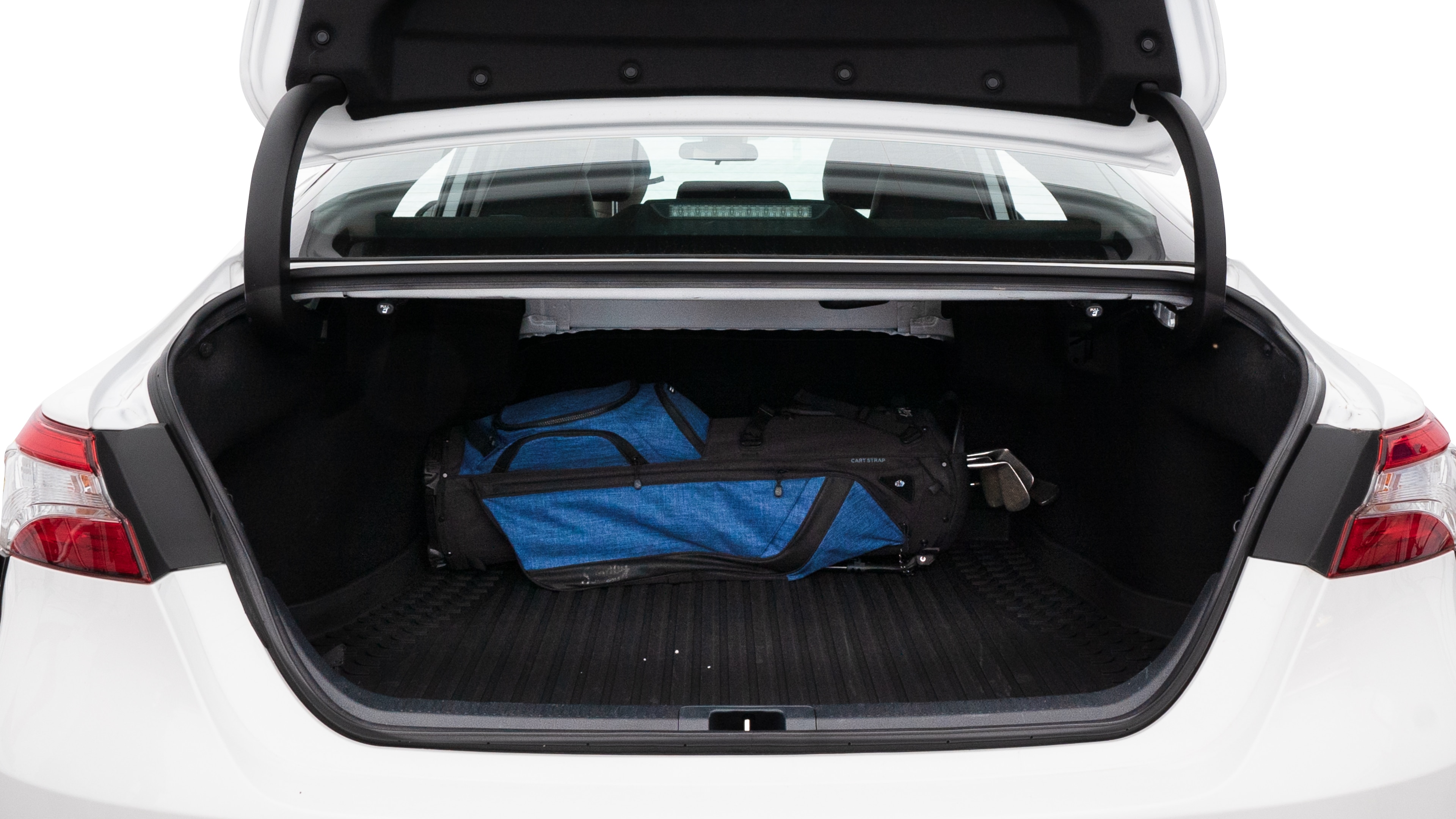 The trunk lid is open showing full view of the trunk. A baby stroller, three grocery carriers, two camping chairs in the carrying bag, and a set of golf clubs are placed inside.