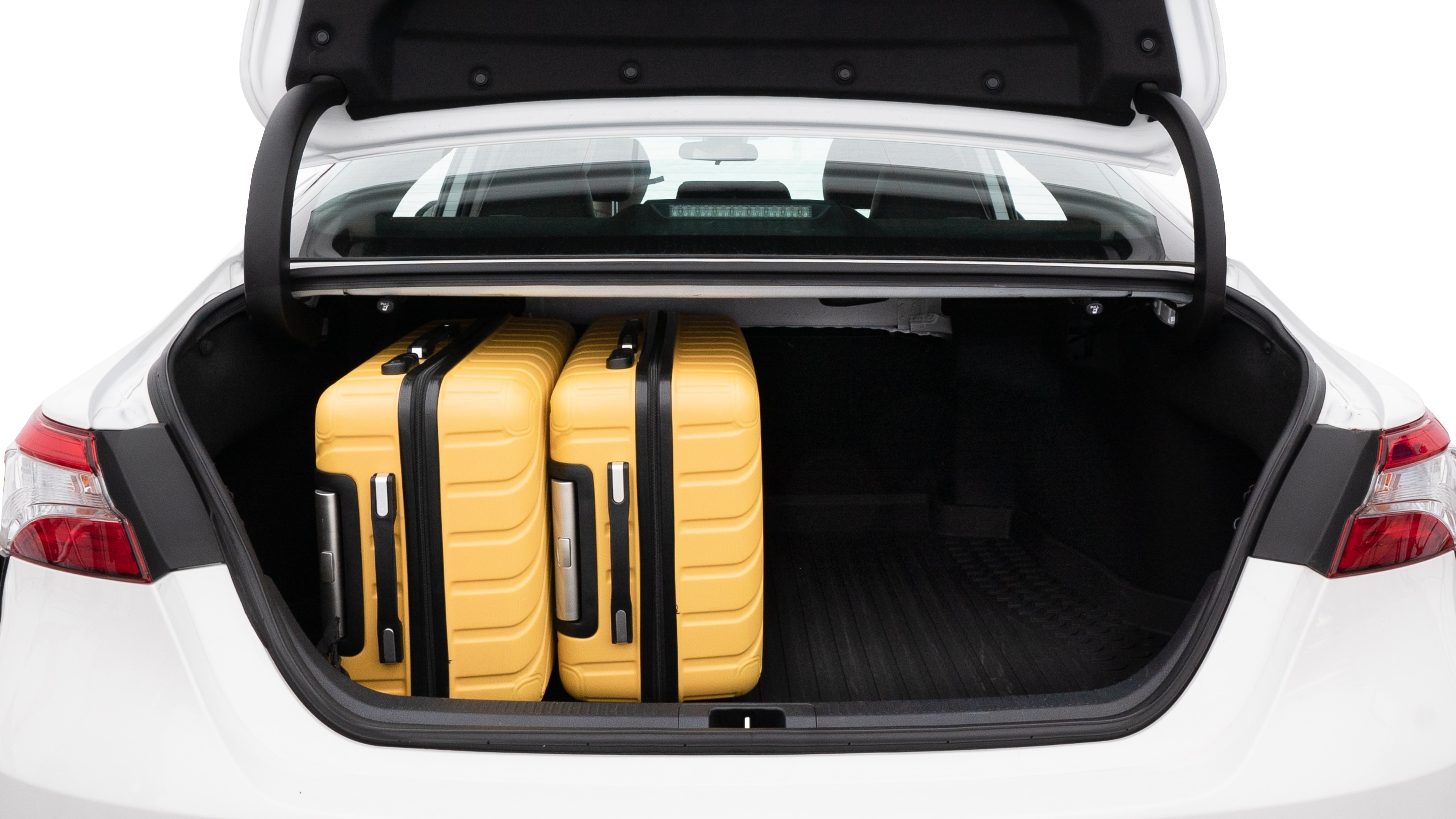 The trunk lid is open, showing full view of the trunk space. Two medium and two small suitcases are placed inside.