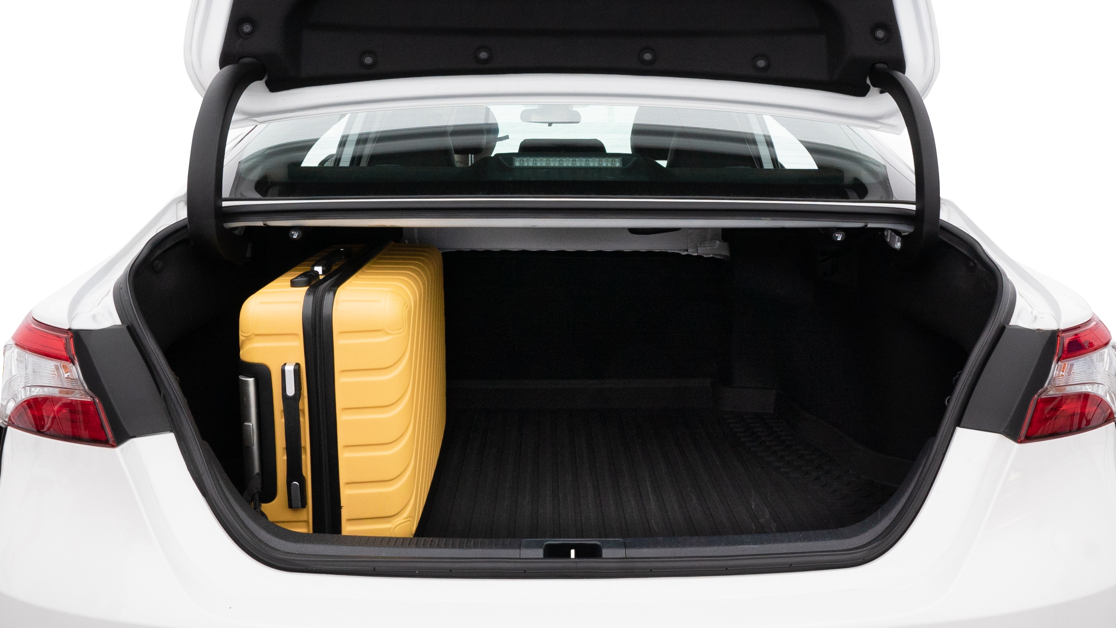 The trunk lid is open, showing full view of the trunk space. Two medium and two small suitcases are placed inside.