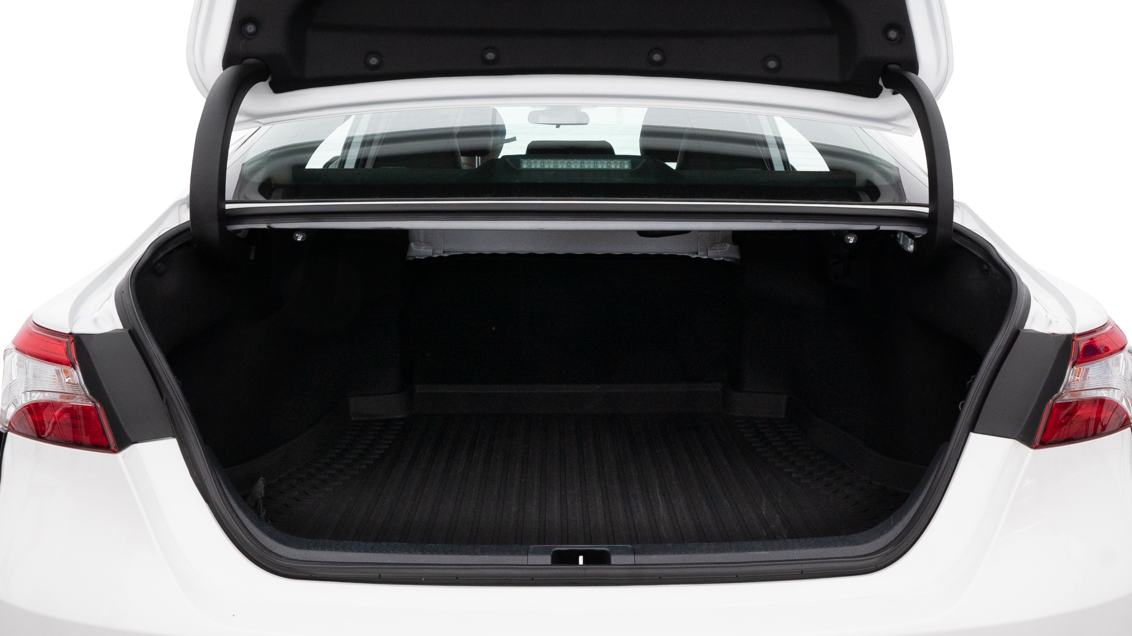 The trunk lid is open, showing full view of the trunk space. Two medium and two small suitcases are placed inside.