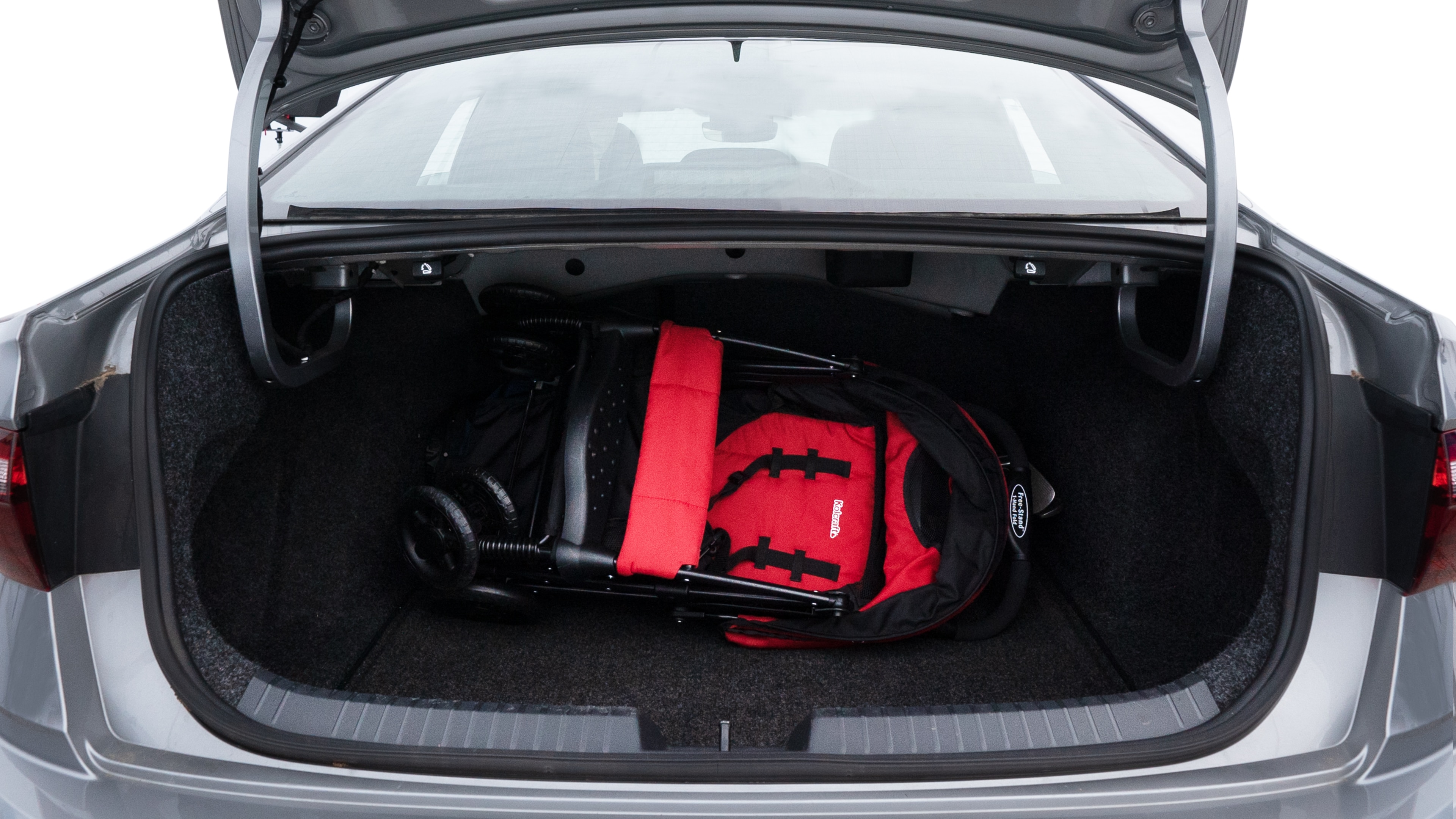 The trunk lid is open showing full view of the trunk. A baby stroller, three grocery carriers, two camping chairs in the carrying bag, and a set of golf clubs are placed inside.
