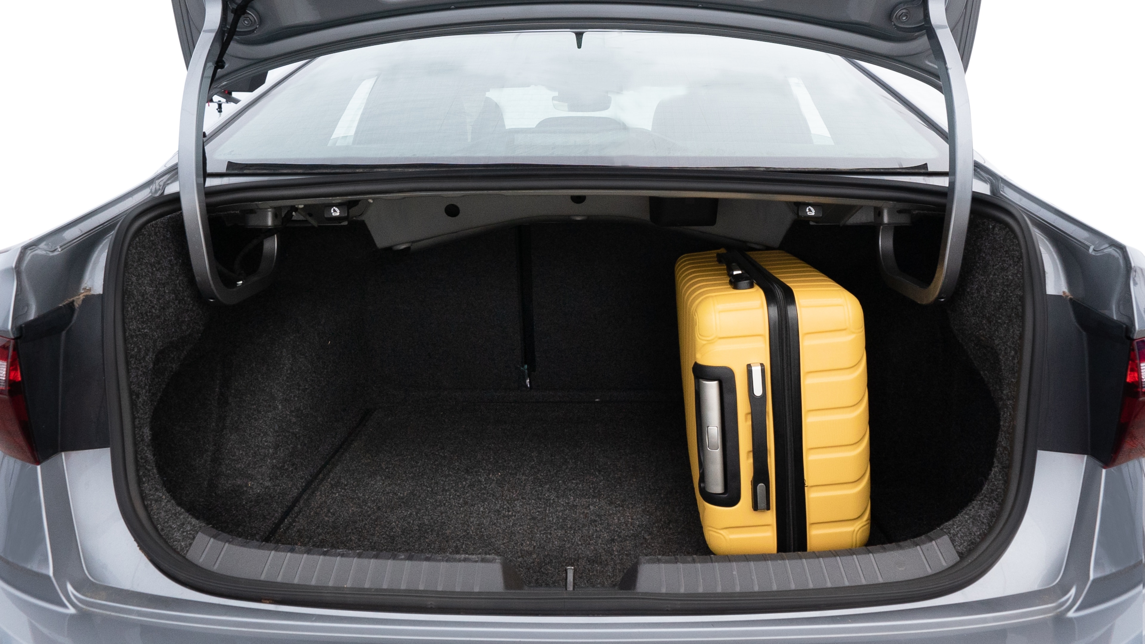 The trunk lid is open, showing full view of the trunk space. Two medium and two small suitcases are placed inside.