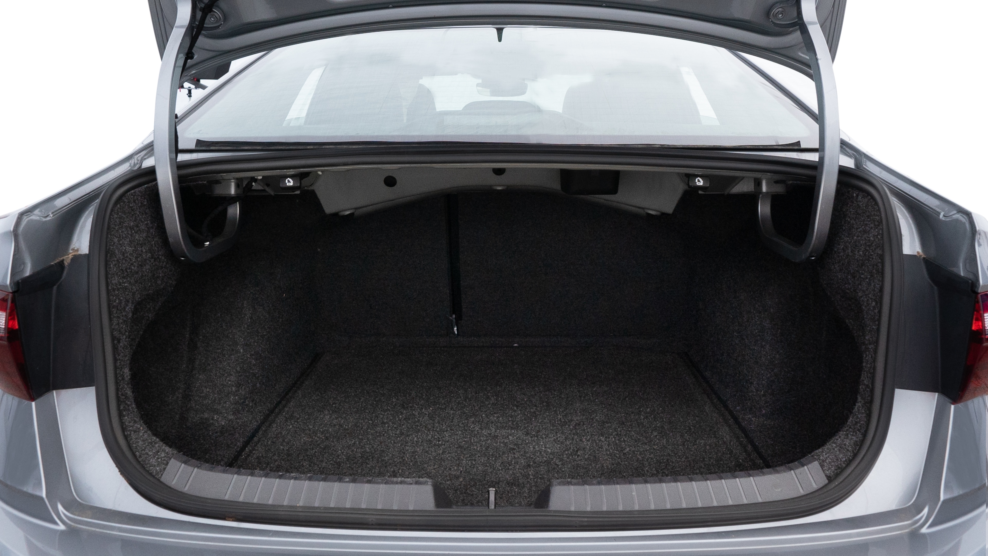 The trunk lid is open, showing full view of the trunk space. Two medium and two small suitcases are placed inside.