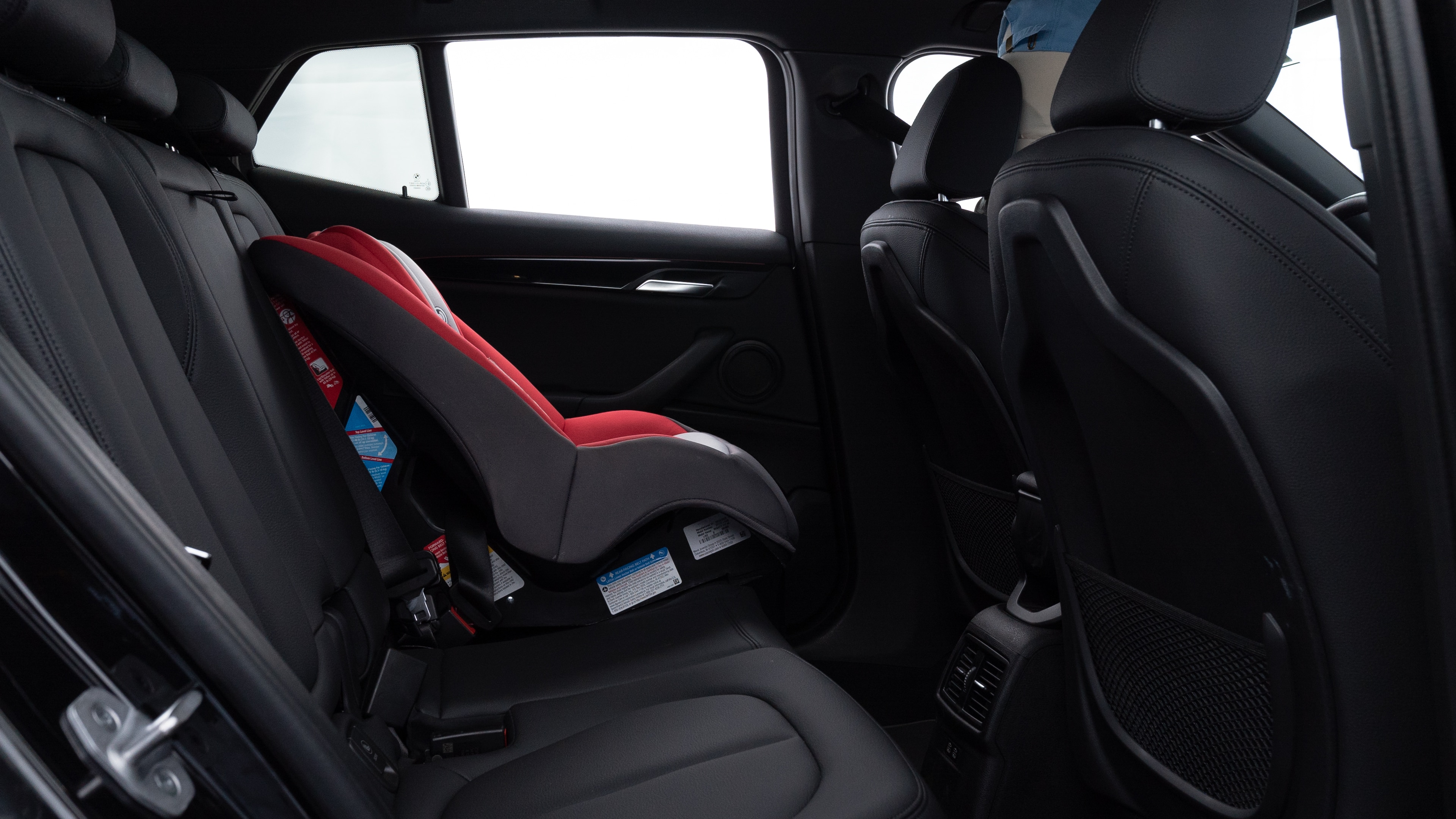 A series of second-row backseat photos is shown including one seating a baby seat and one seating a 6'1" mannequin.