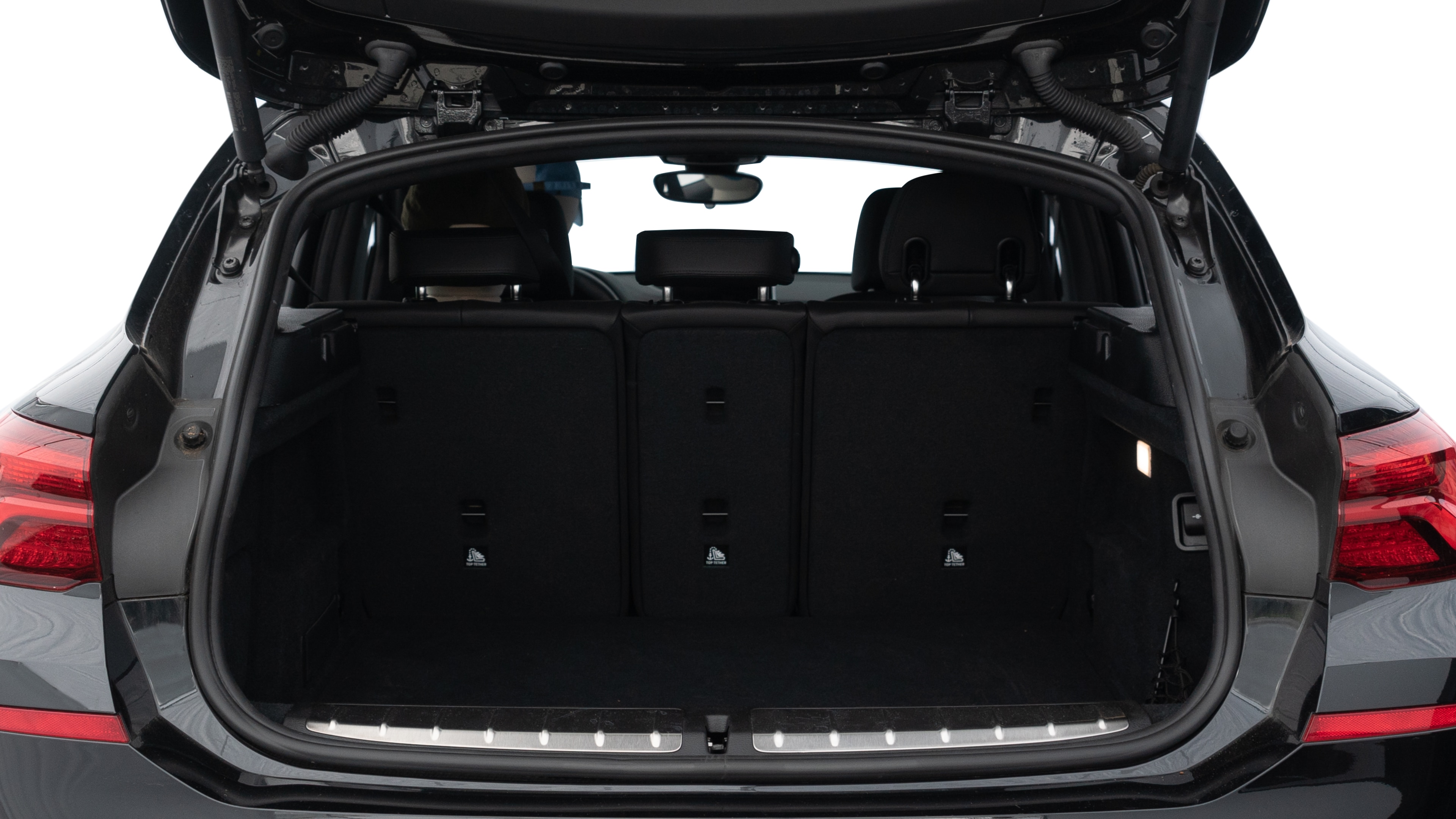 The trunk lid is open showing full view of the trunk. A baby stroller, three grocery carriers, two camping chairs in the carrying bag, and a set of golf clubs are placed inside.