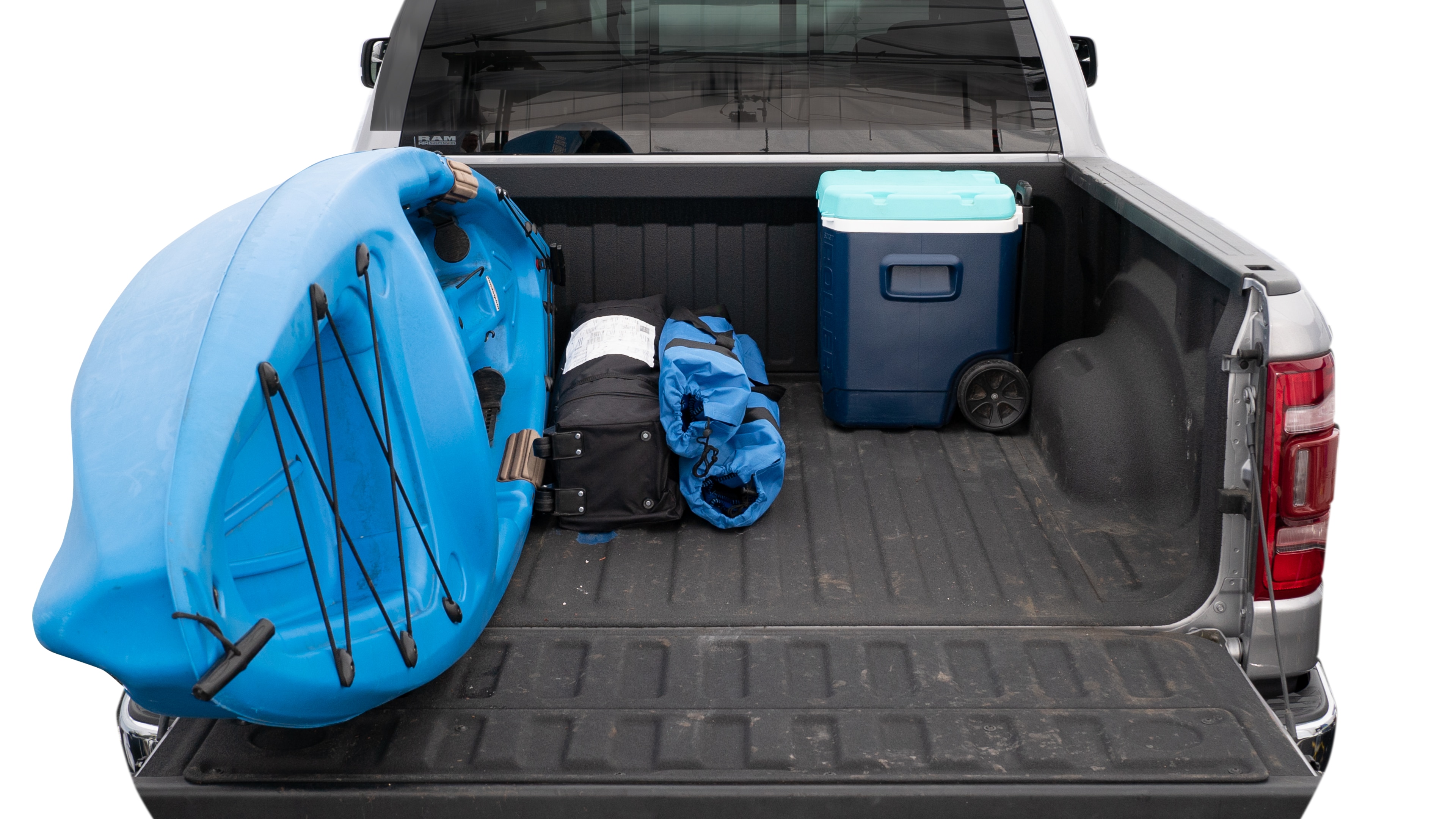 The trunk area is open giving a full view of the trunk area. A cooler, two camping chairs, a tailgate tent and a kayak are placed inside. 