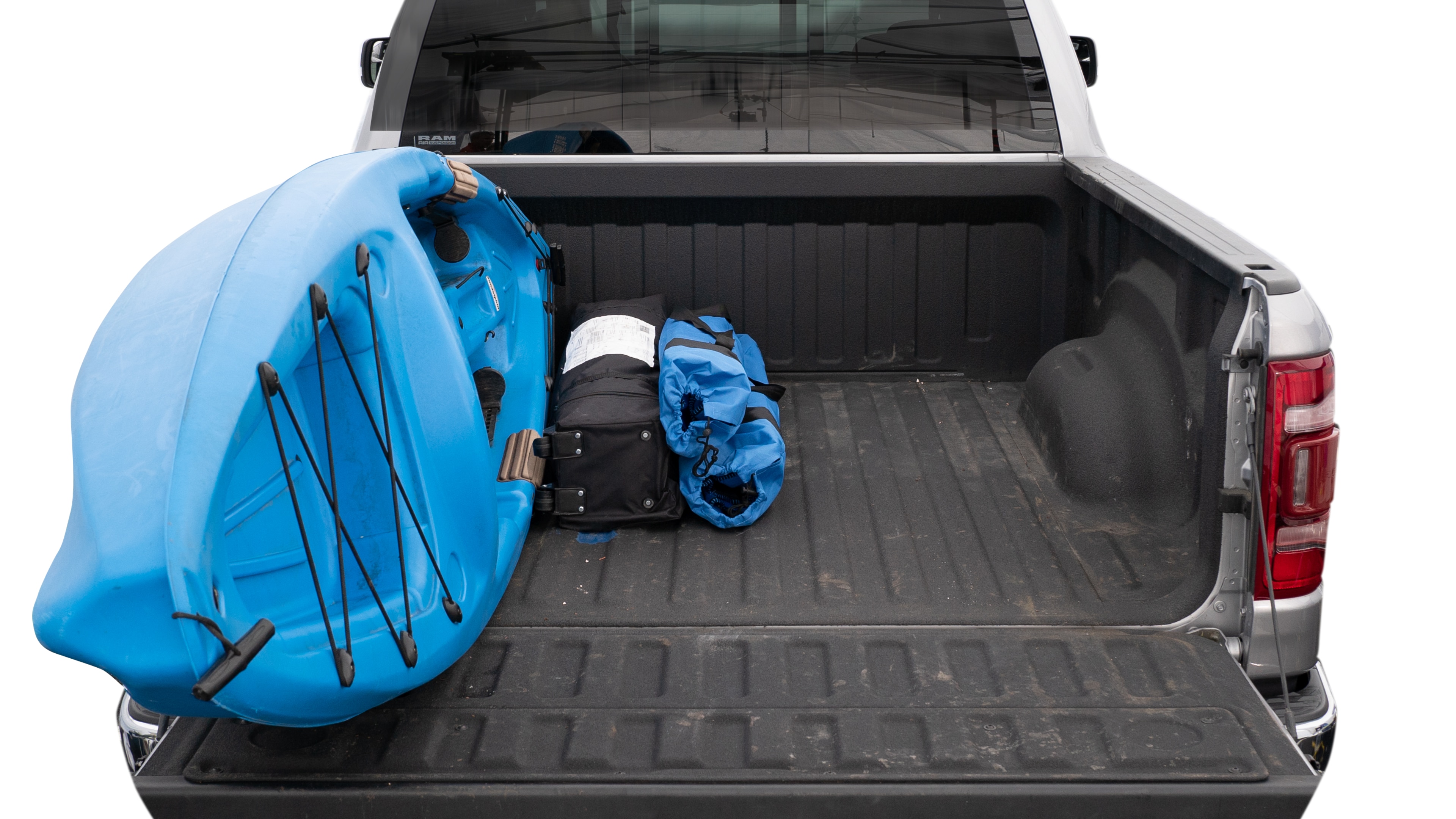 The trunk area is open giving a full view of the trunk area. A cooler, two camping chairs, a tailgate tent and a kayak are placed inside. 
