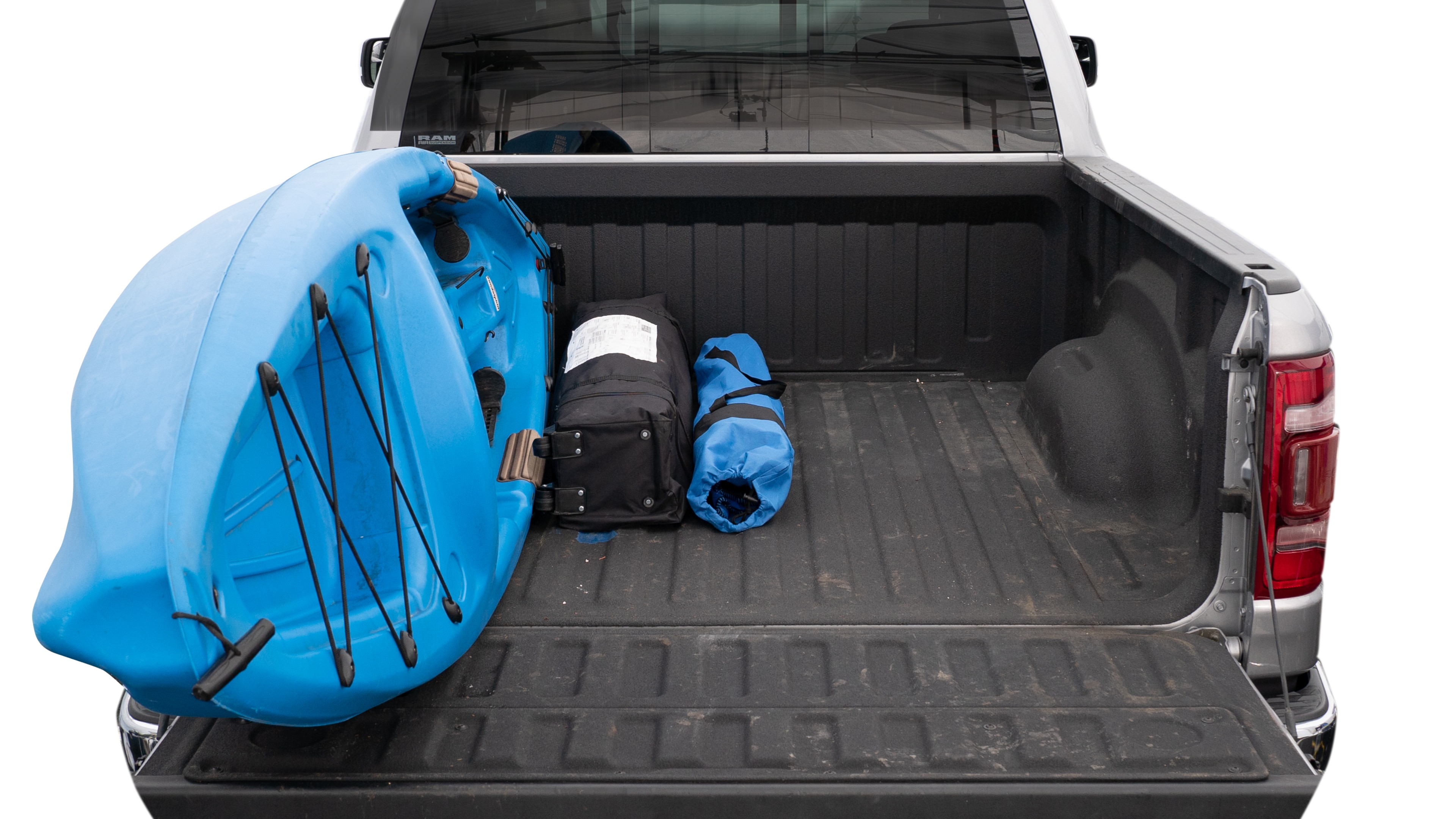 The trunk area is open giving a full view of the trunk area. A cooler, two camping chairs, a tailgate tent and a kayak are placed inside. 