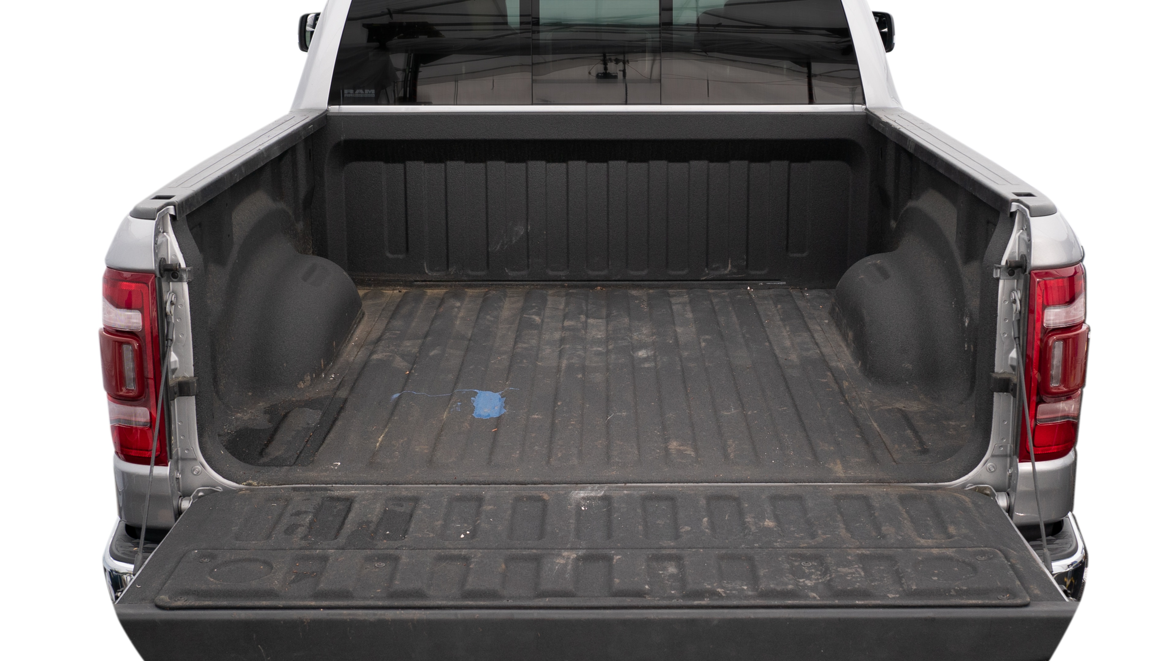 The trunk area is open giving a full view of the trunk area. A ladder, three 2 by 4 framing studs, two tool boxes and a 4 by 8 drywall sheet are placed inside. 