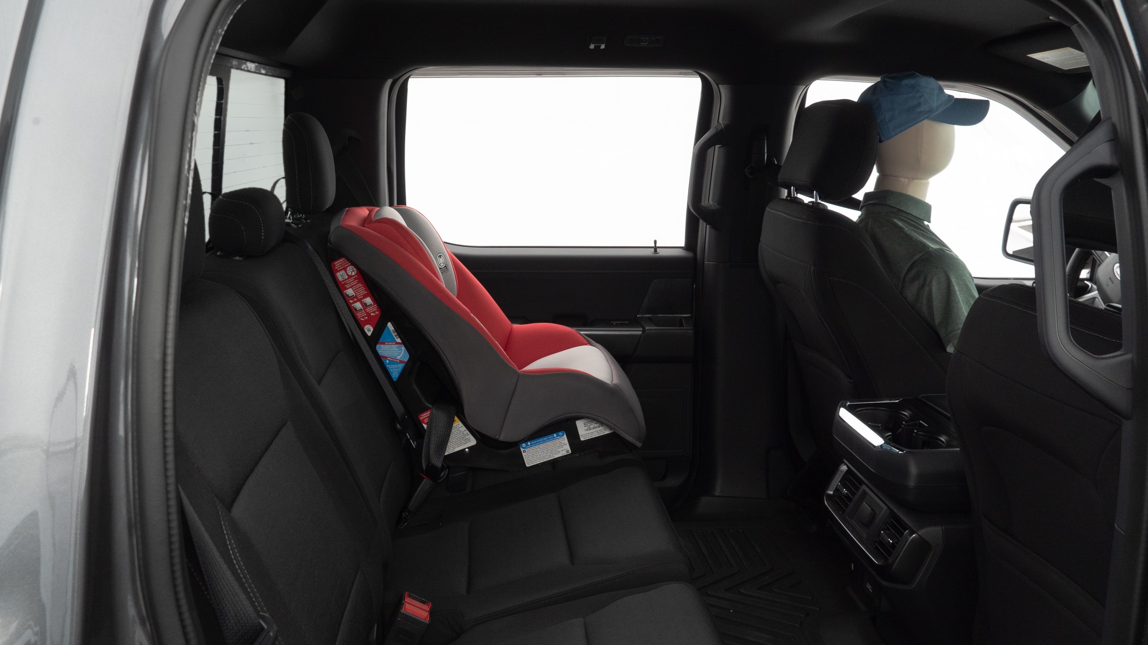 A series of second-row backseat photos is shown including one seating a baby seat and one seating a 6'1" mannequin.