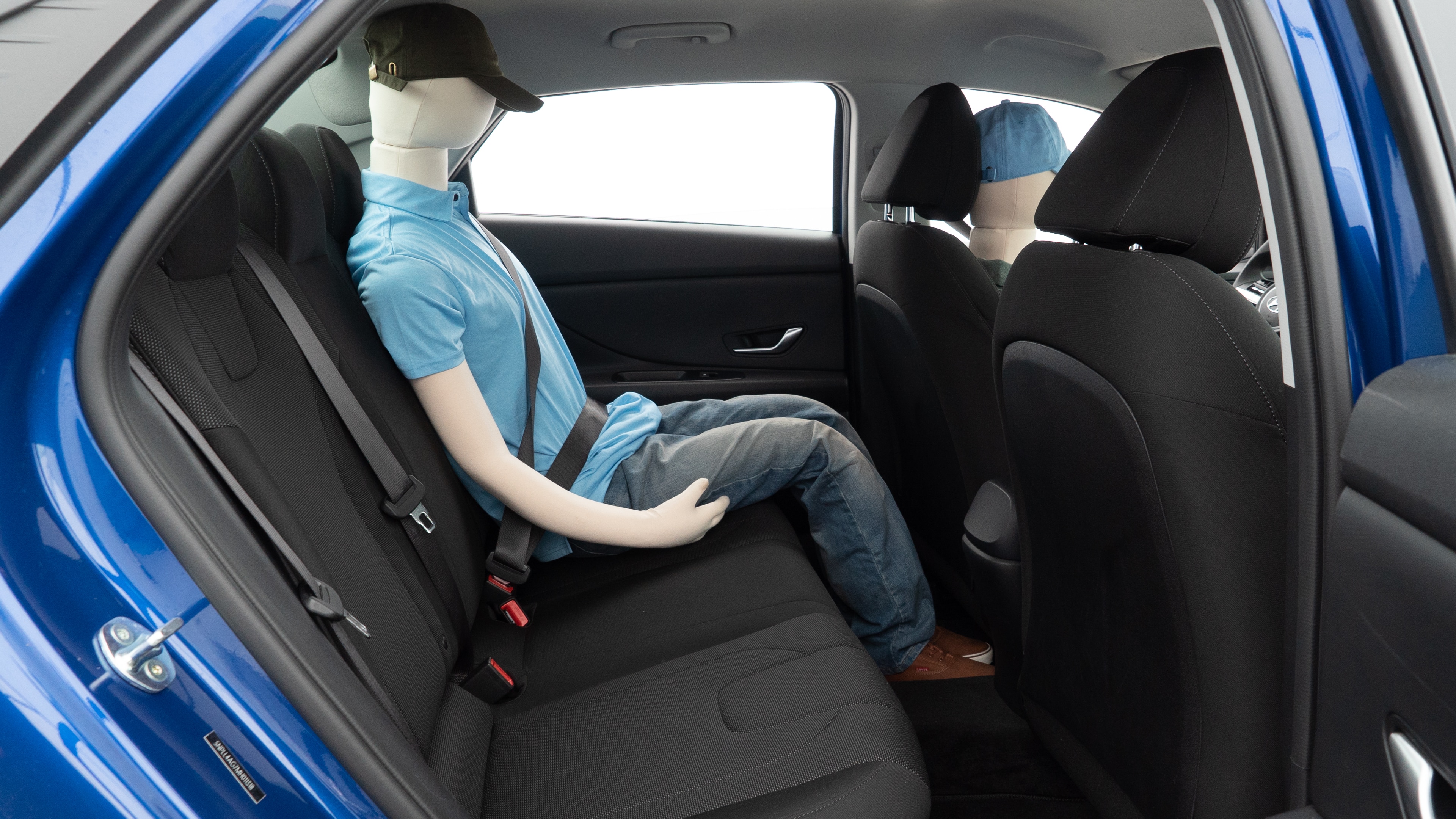 A series of second-row backseat photos is shown including one seating a baby seat and one seating a 6'1" mannequin.