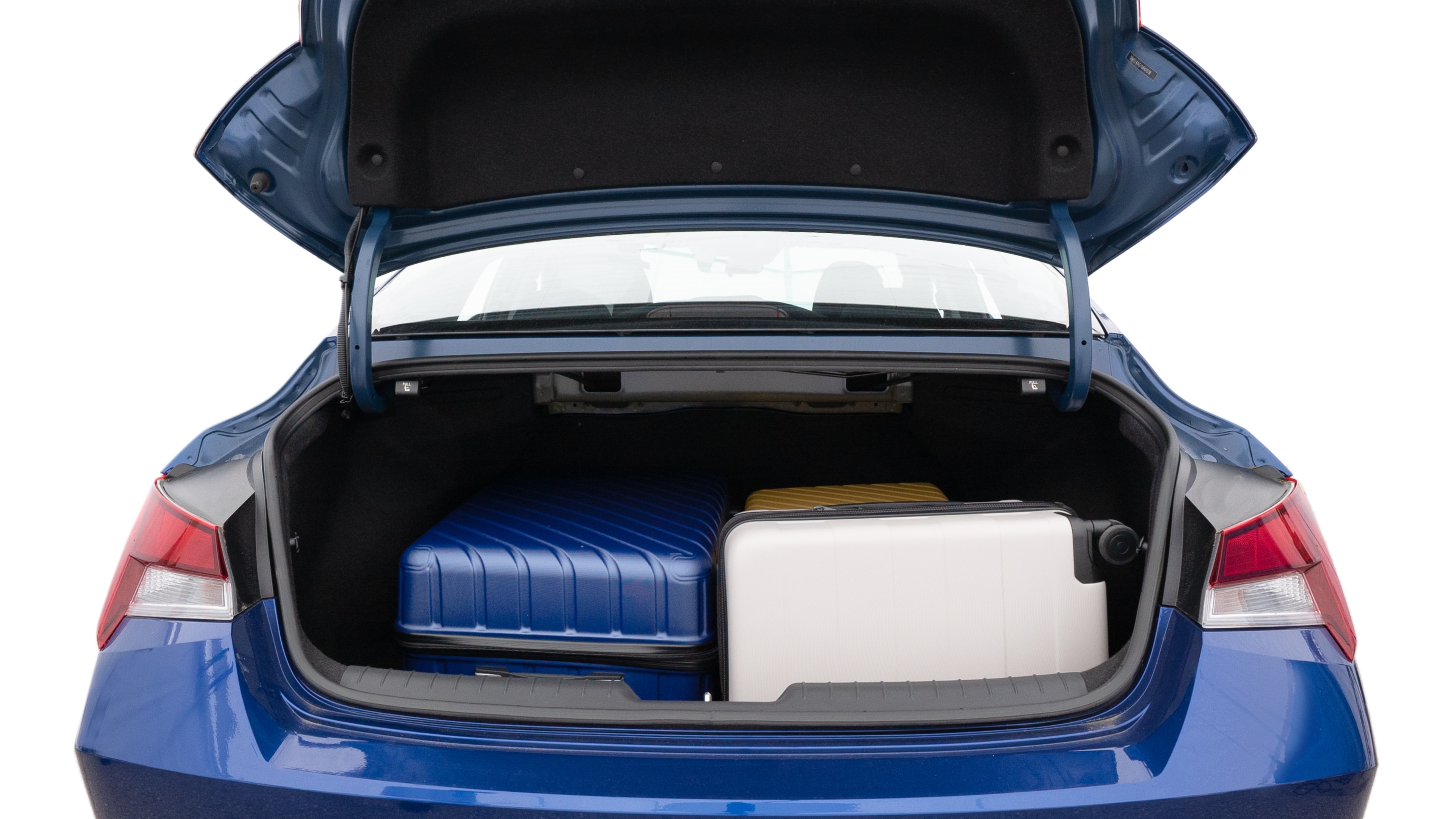 The trunk lid is open, showing full view of the trunk space. One large, one medium and one small suitcases are placed inside.