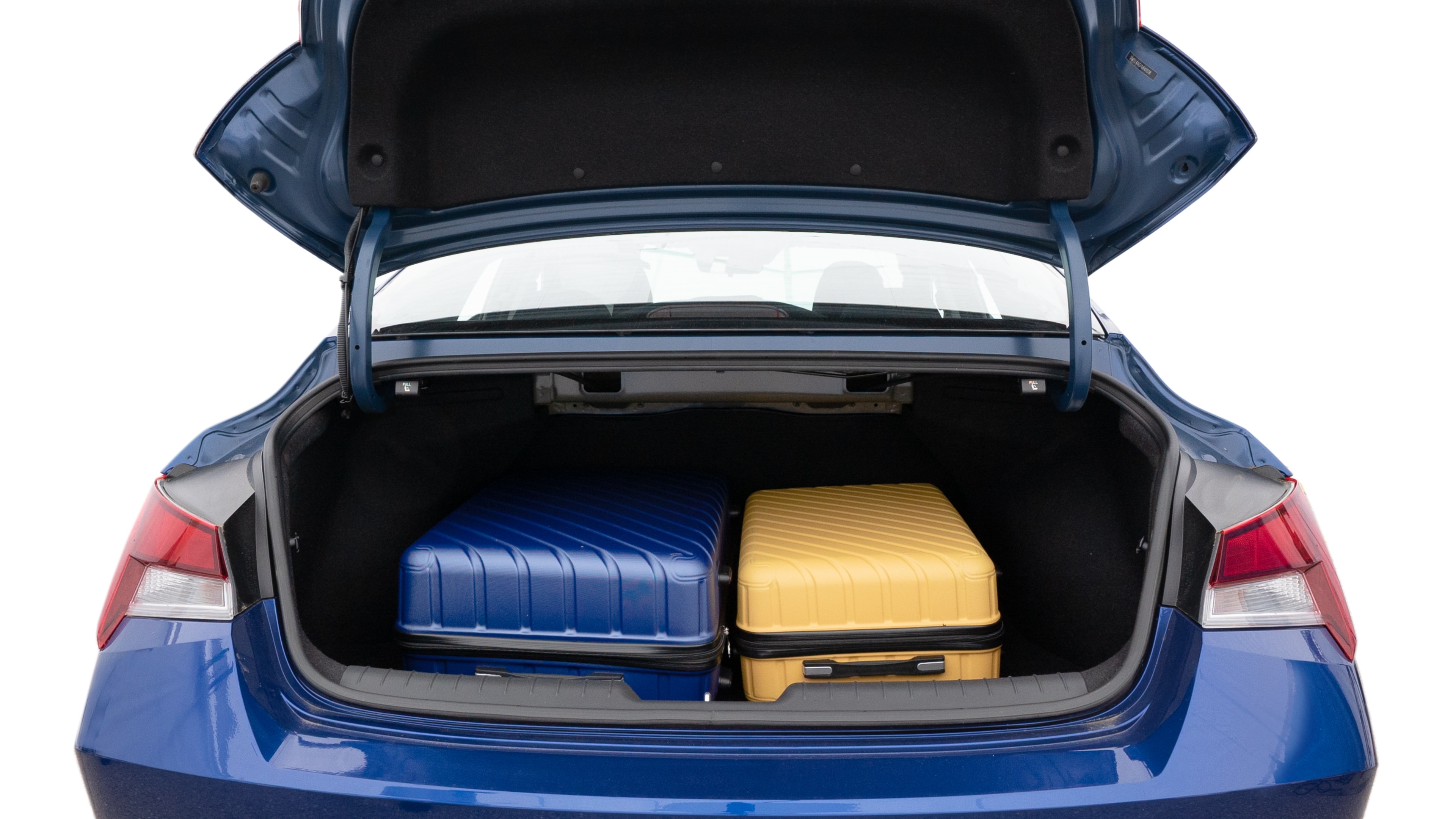 The trunk lid is open, showing full view of the trunk space. One large, one medium and one small suitcases are placed inside.