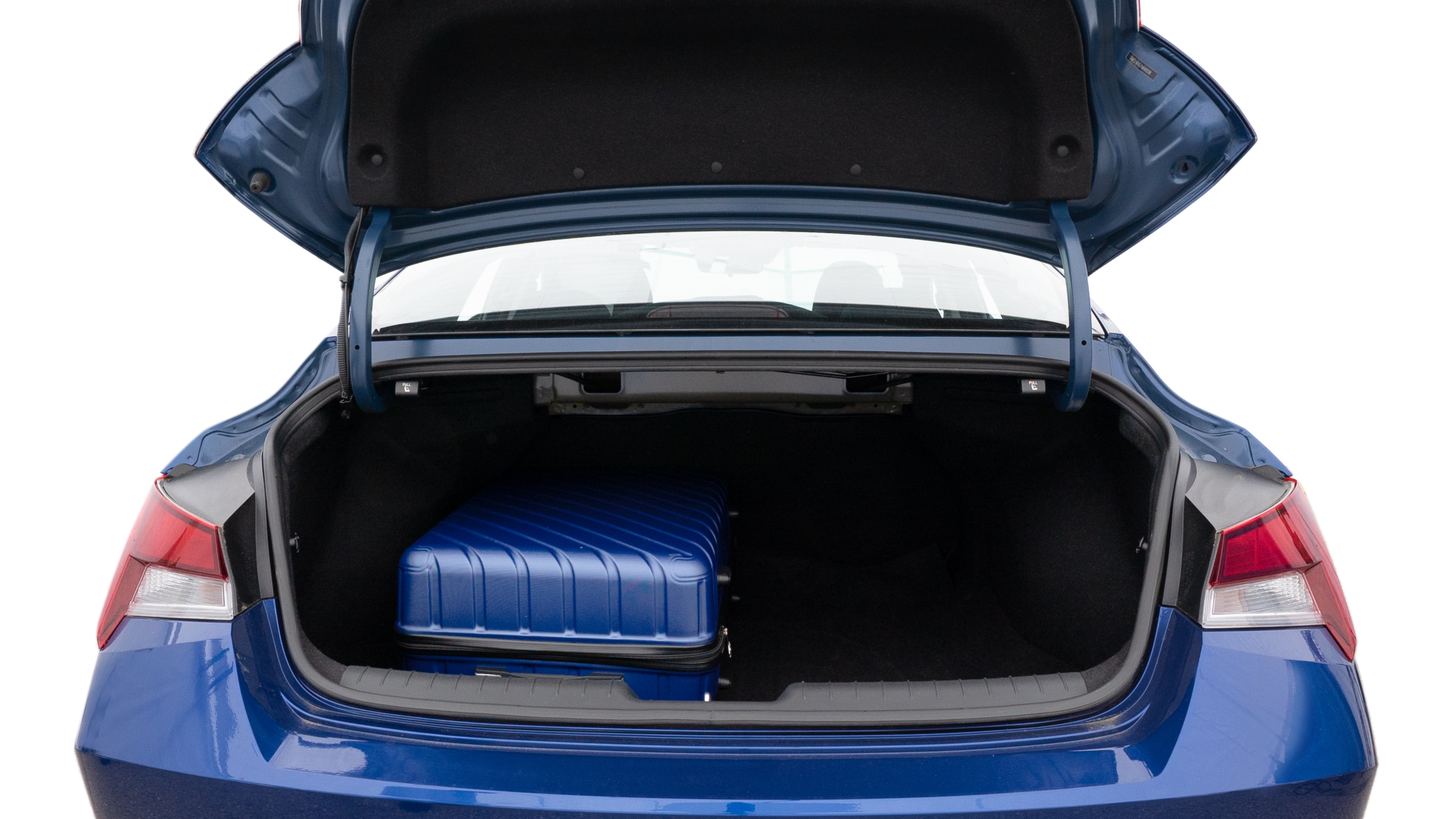 The trunk lid is open, showing full view of the trunk space. One large, one medium and one small suitcases are placed inside.