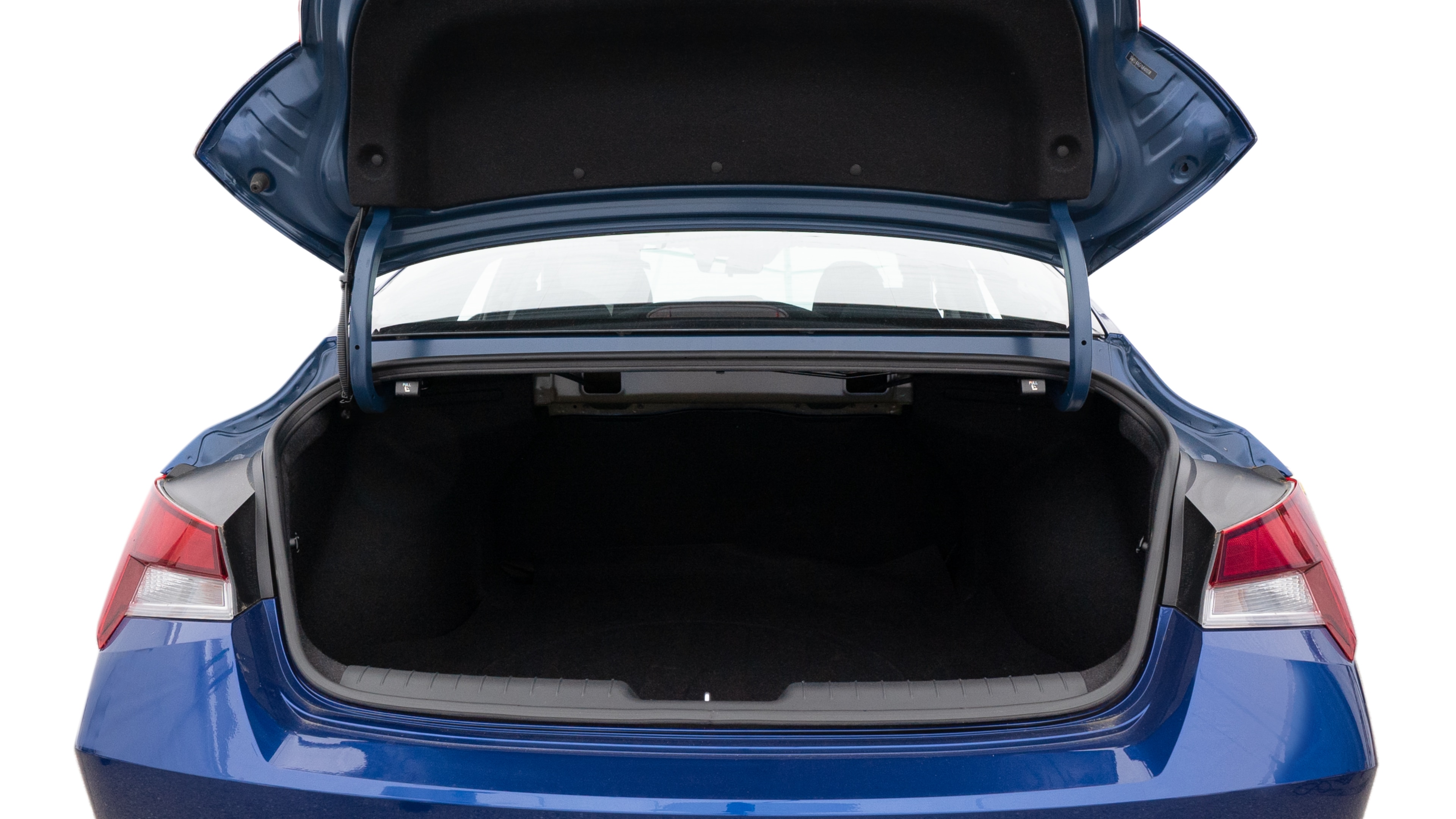 The trunk lid is open, showing full view of the trunk space. One large, one medium and one small suitcases are placed inside.
