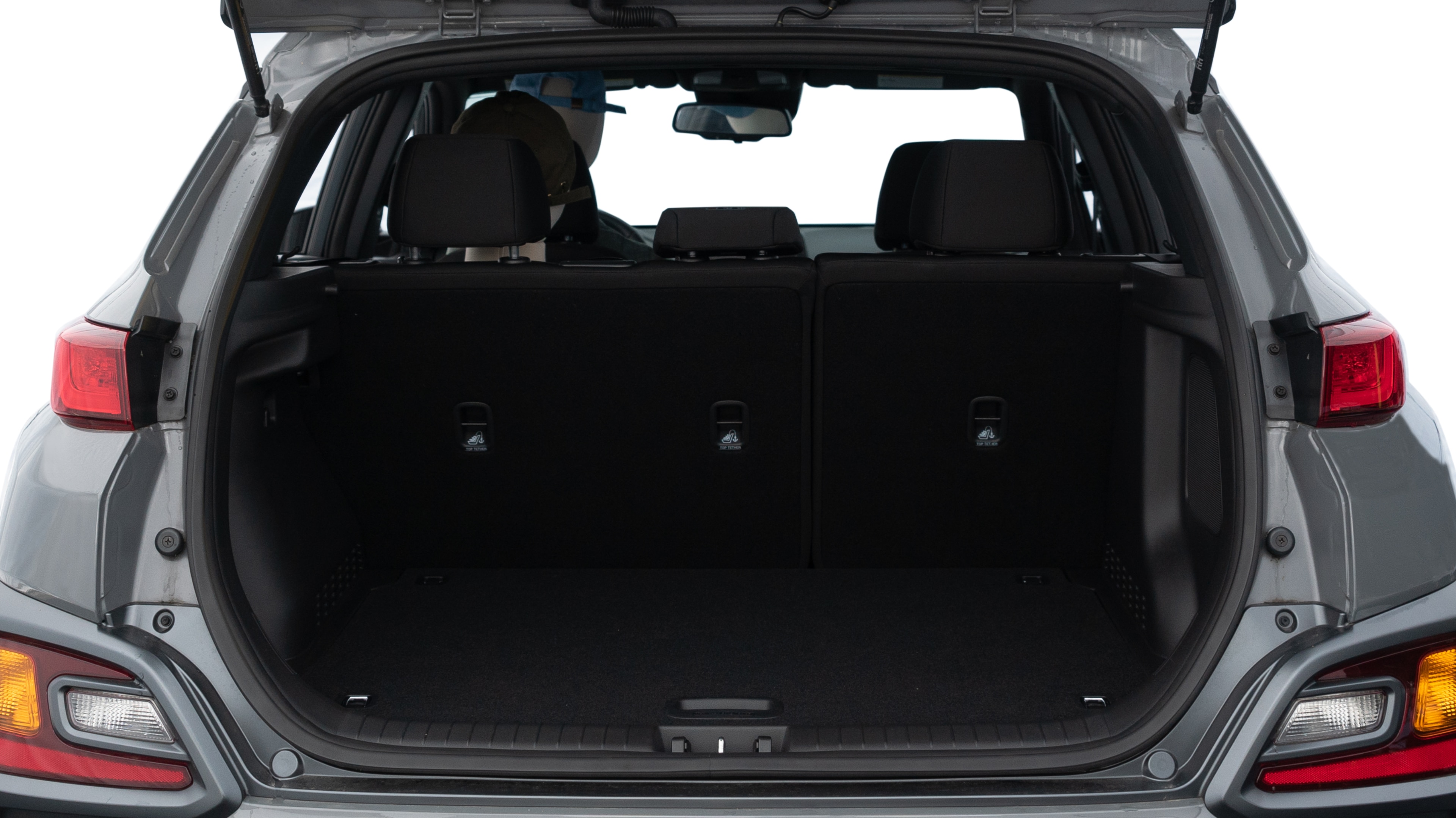 The trunk lid is open, showing full view of the trunk space. One medium and two small suitcases are placed inside.