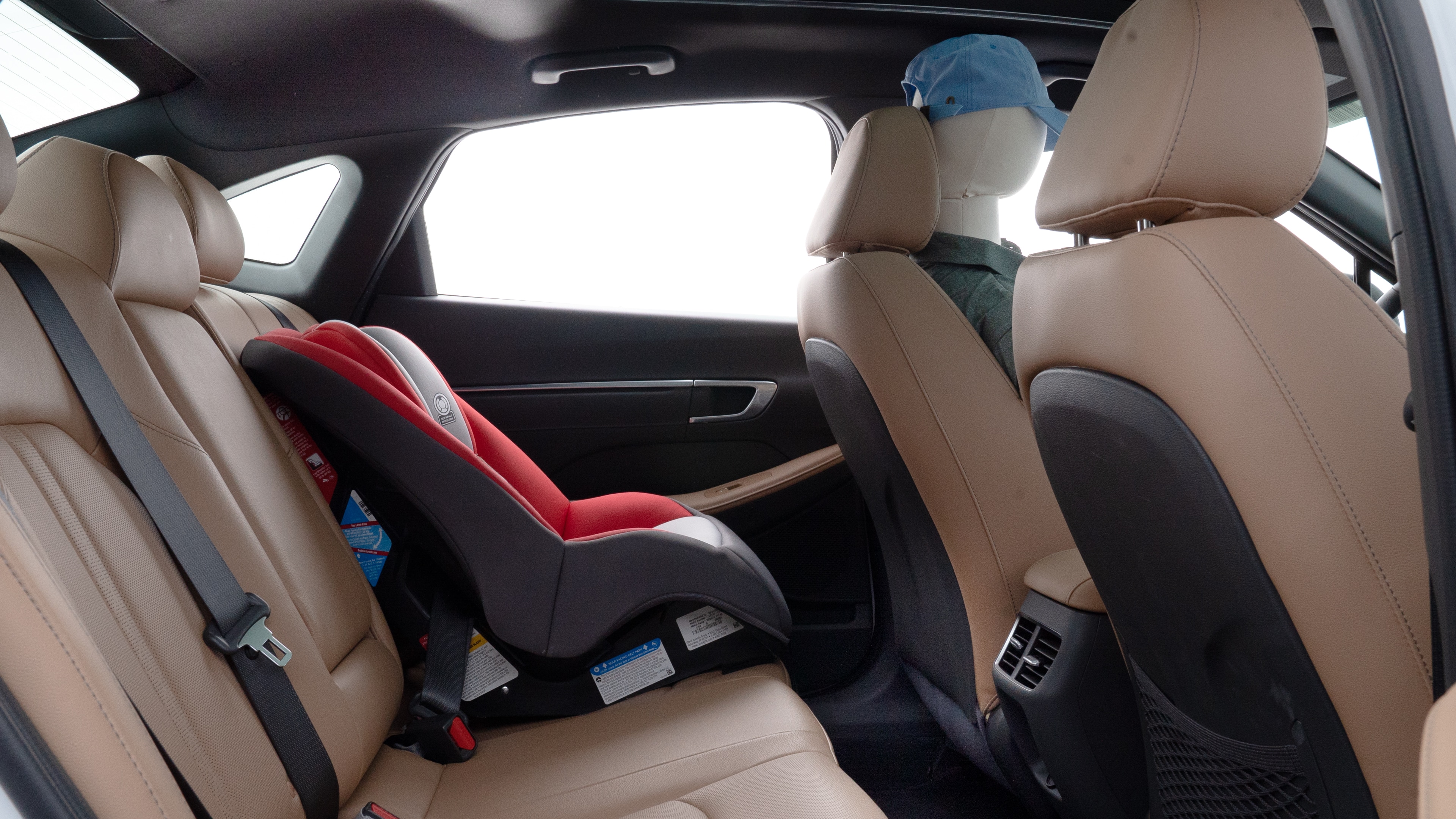 A series of second-row backseat photos is shown including one seating a baby seat and one seating a 6'1" mannequin.