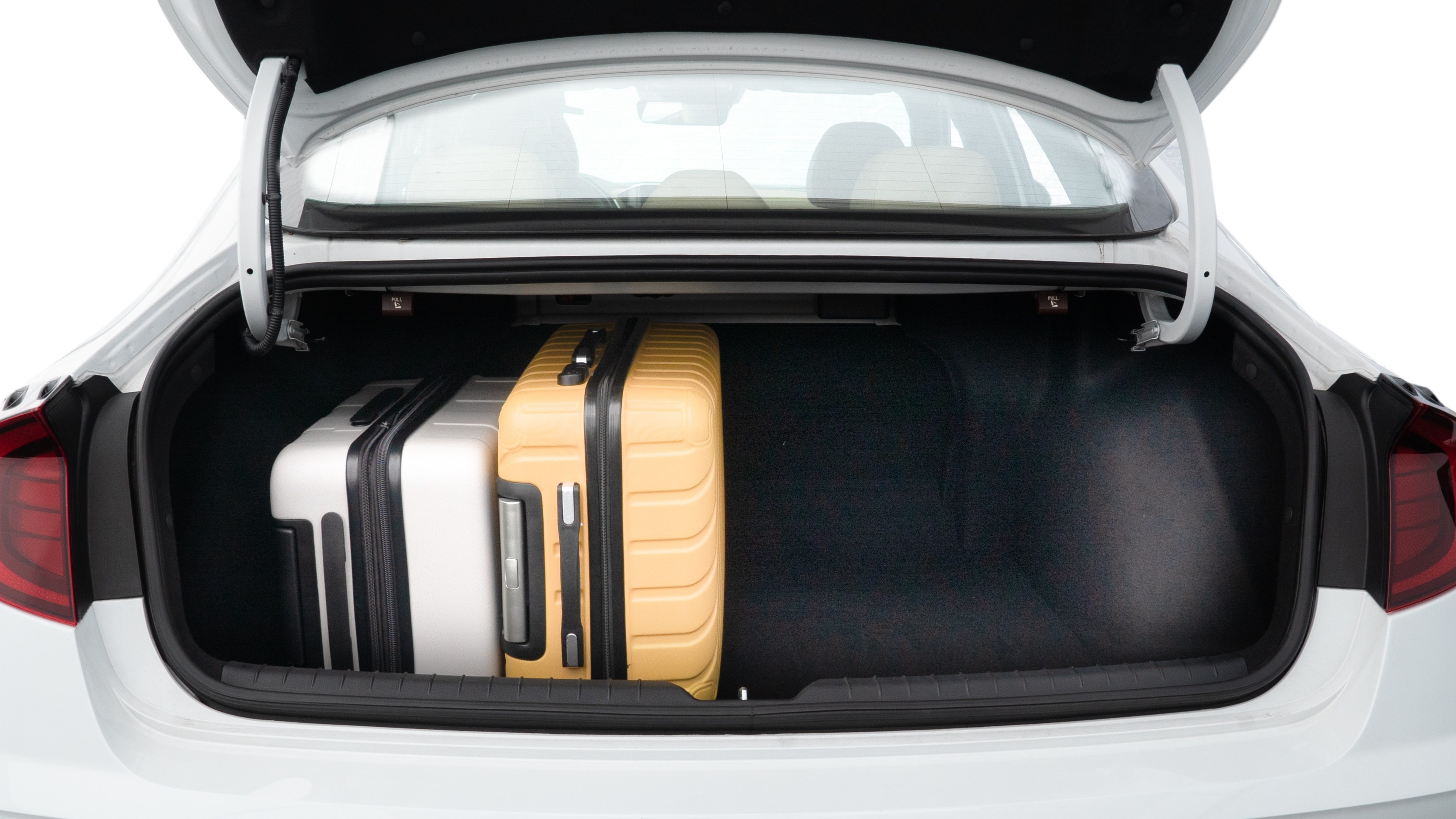 The trunk lid is open, showing full view of the trunk space. Two medium and two small suitcases are placed inside.