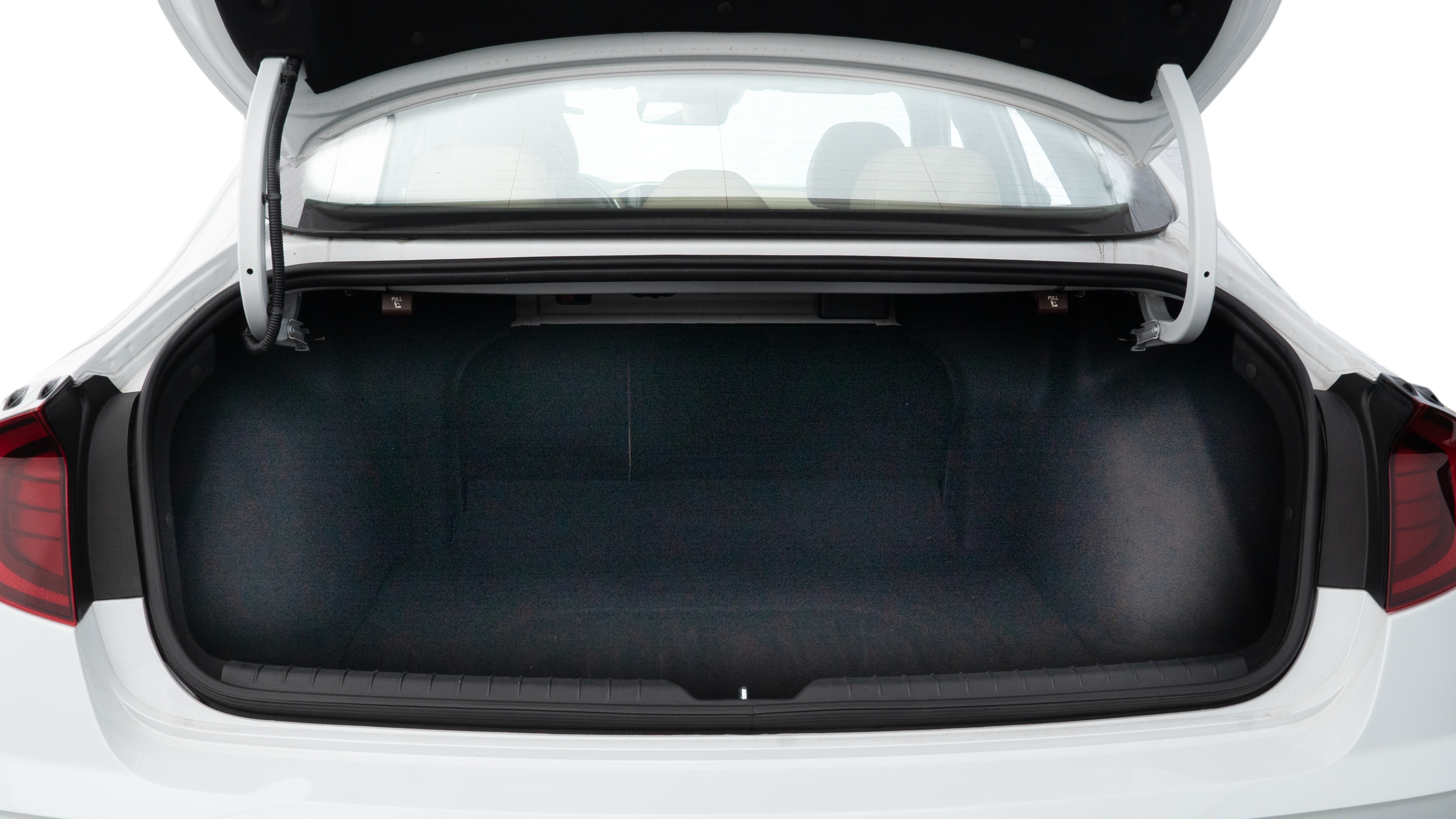 The trunk lid is open, showing full view of the trunk space. Two medium and two small suitcases are placed inside.