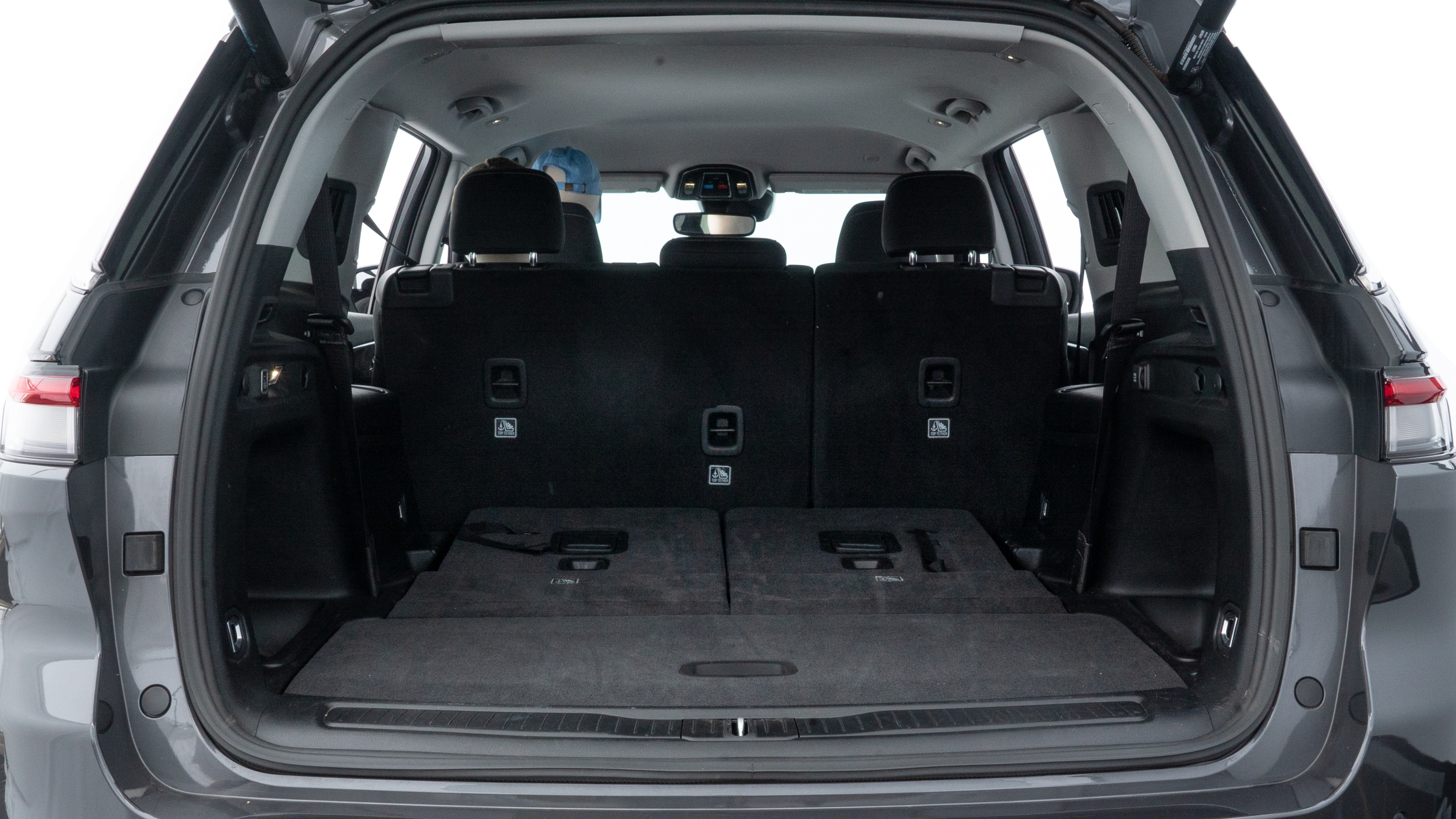 The trunk lid is open showing full view of the trunk. A baby stroller, three grocery carriers, two camping chairs in the carrying bag, and a set of golf clubs are placed inside.