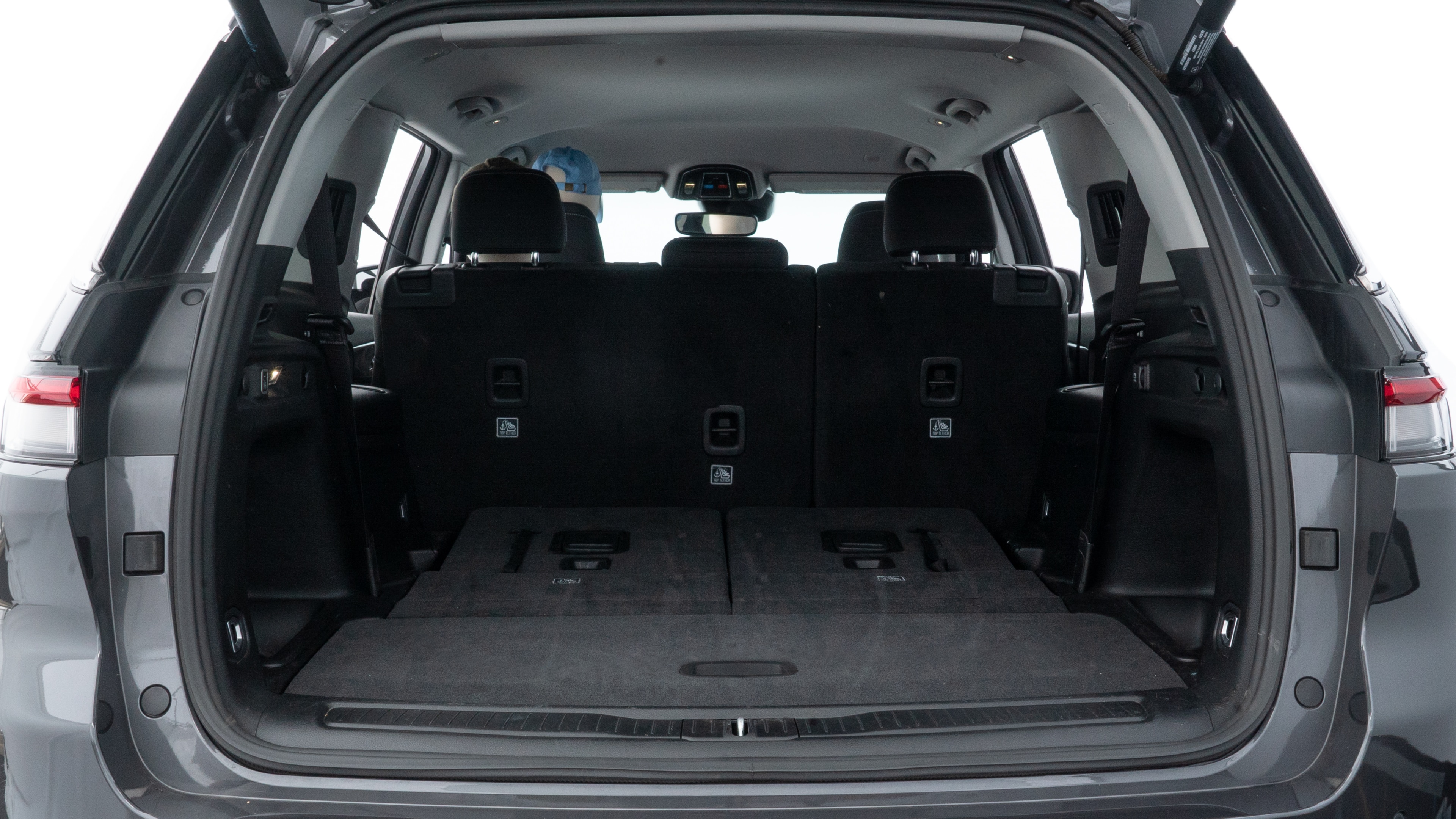 The trunk lid is open, showing full view of the trunk space. One large, two medium, and two small suitcases are placed inside.