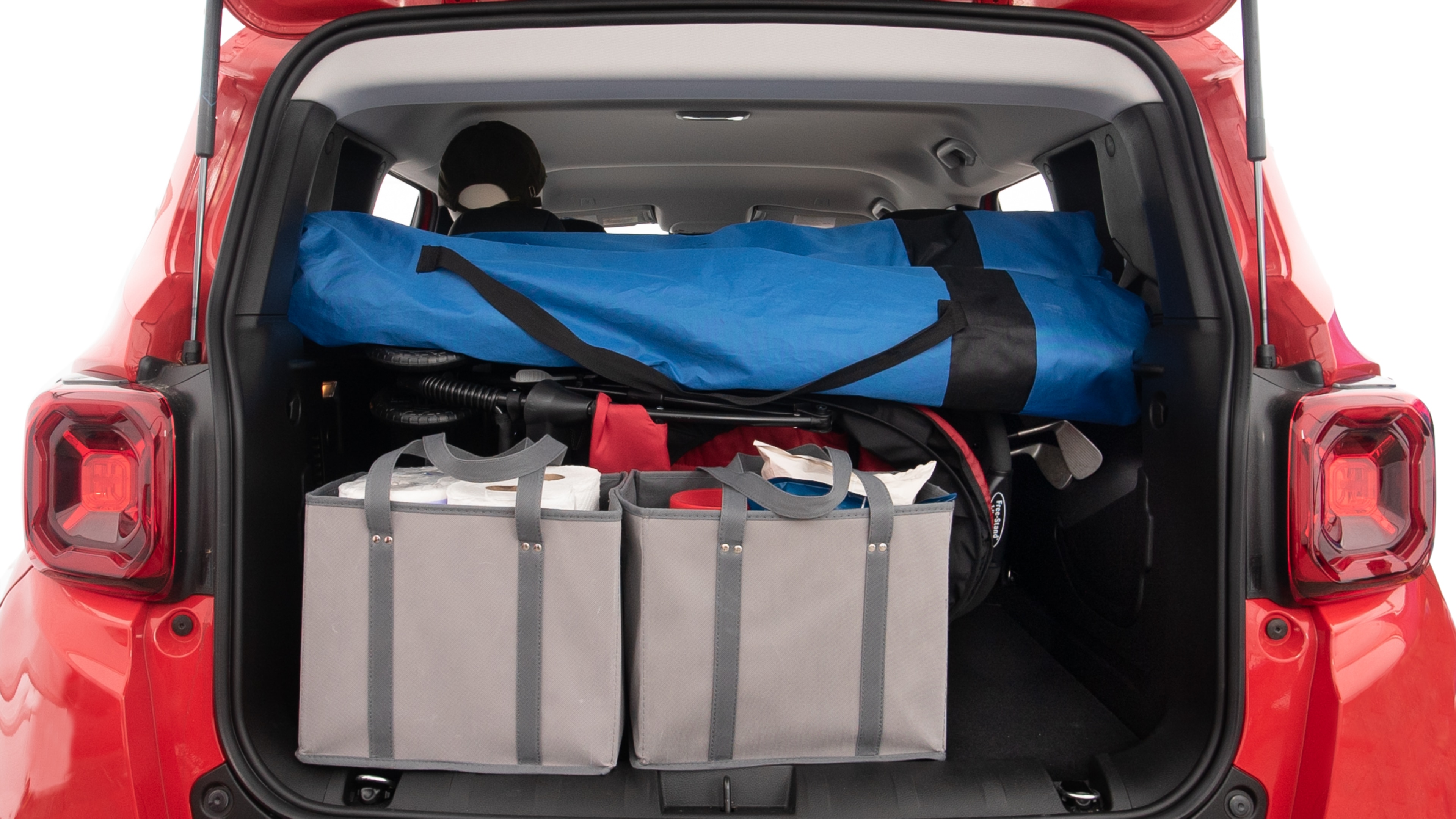 The trunk lid is open showing full view of the trunk. A baby stroller, three grocery carriers, two camping chairs in the carrying bag, and a set of golf clubs are placed inside.