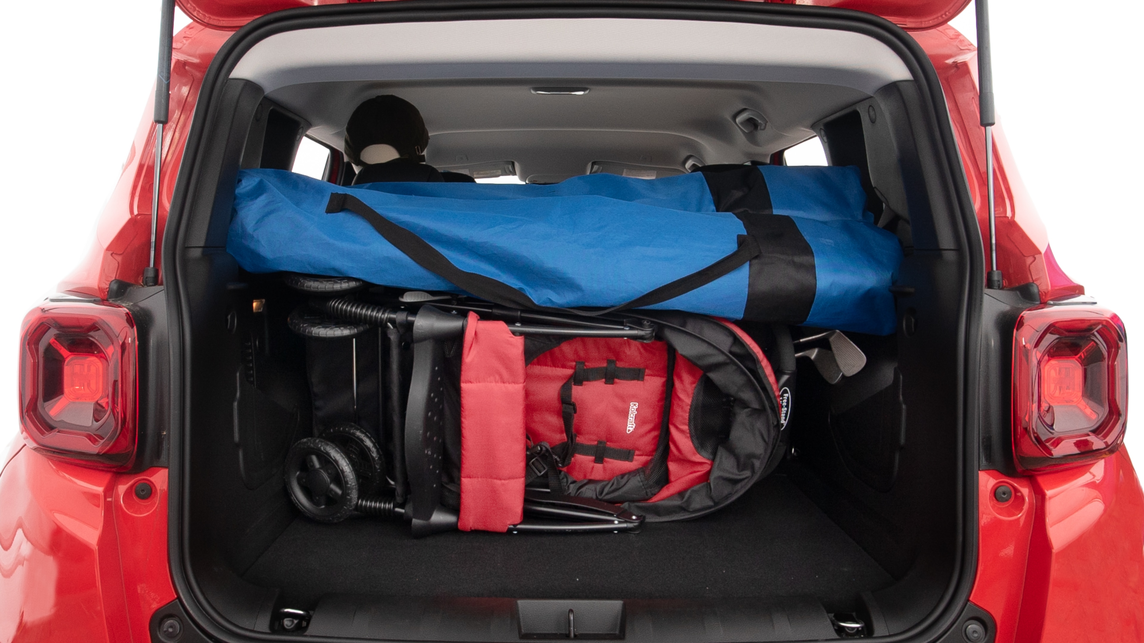 The trunk lid is open showing full view of the trunk. A baby stroller, three grocery carriers, two camping chairs in the carrying bag, and a set of golf clubs are placed inside.