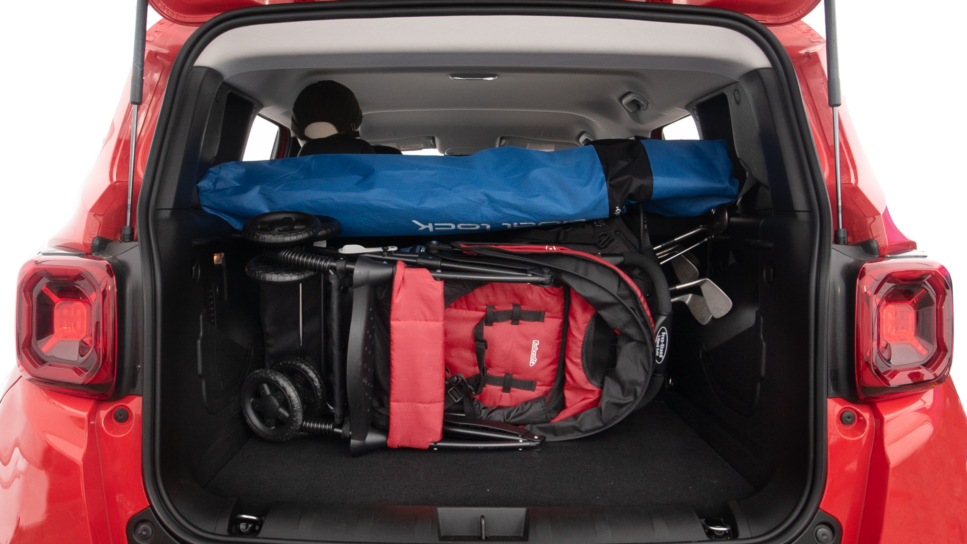 The trunk lid is open showing full view of the trunk. A baby stroller, three grocery carriers, two camping chairs in the carrying bag, and a set of golf clubs are placed inside.
