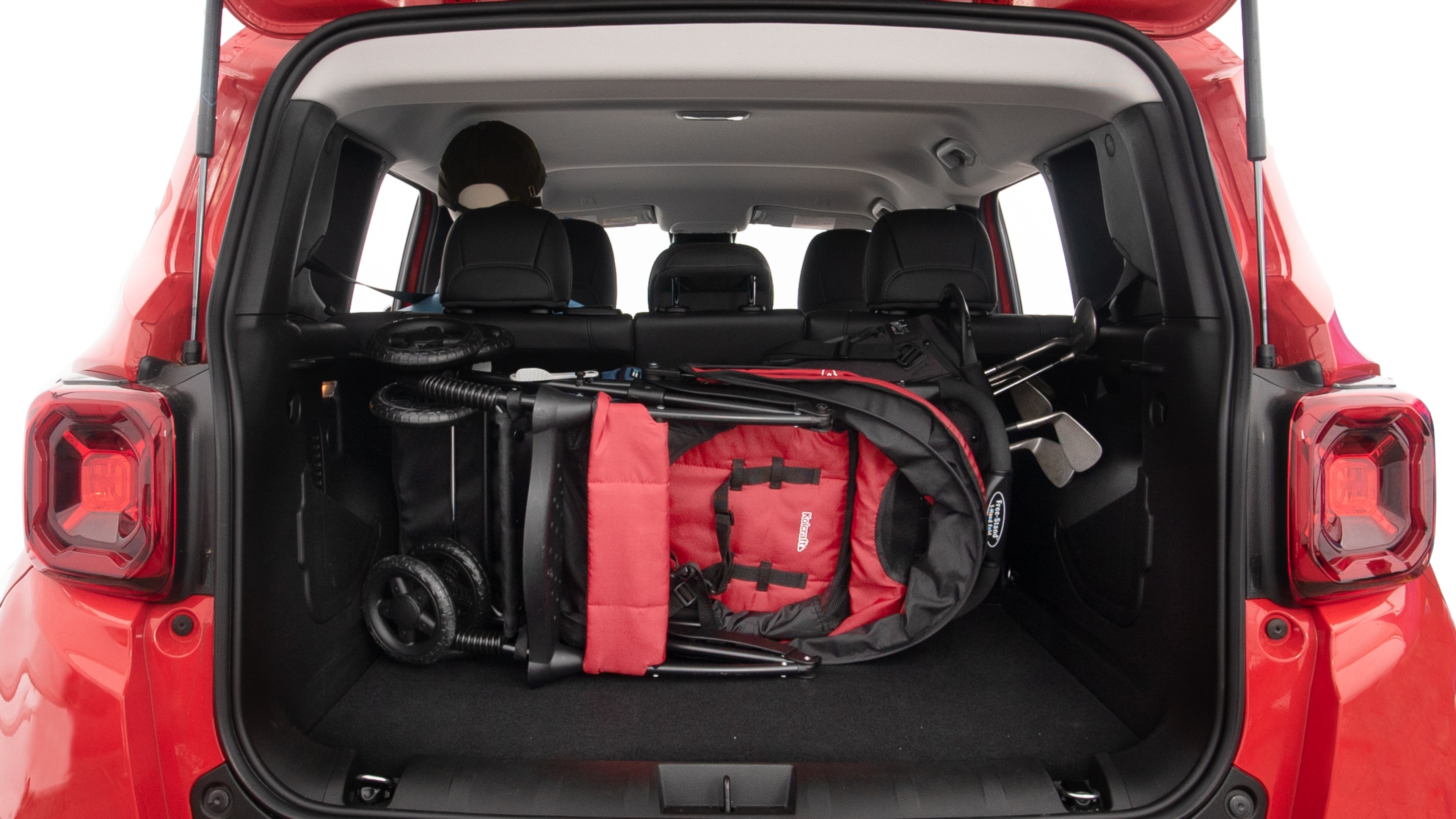 The trunk lid is open showing full view of the trunk. A baby stroller, three grocery carriers, two camping chairs in the carrying bag, and a set of golf clubs are placed inside.
