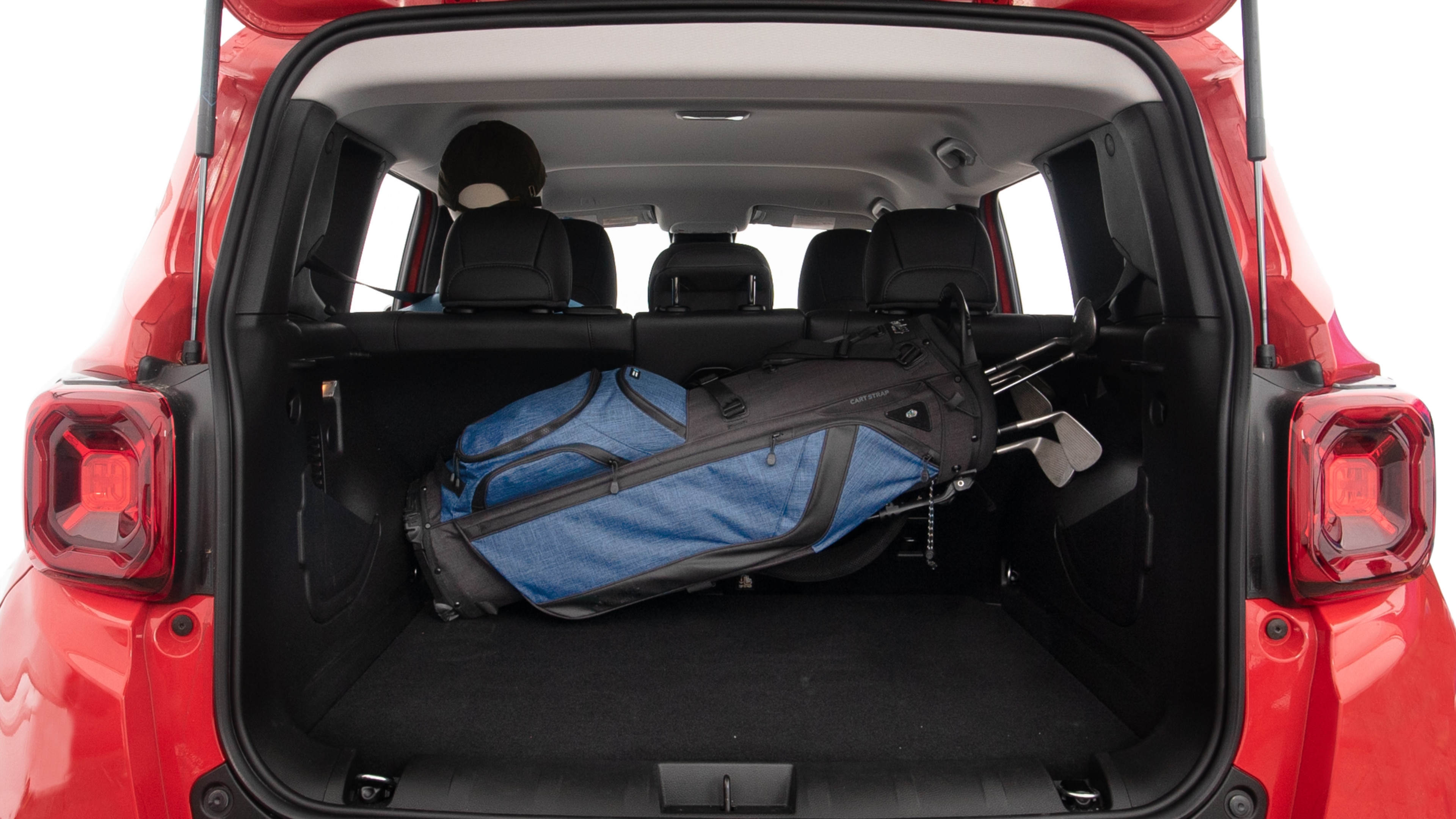 The trunk lid is open showing full view of the trunk. A baby stroller, three grocery carriers, two camping chairs in the carrying bag, and a set of golf clubs are placed inside.