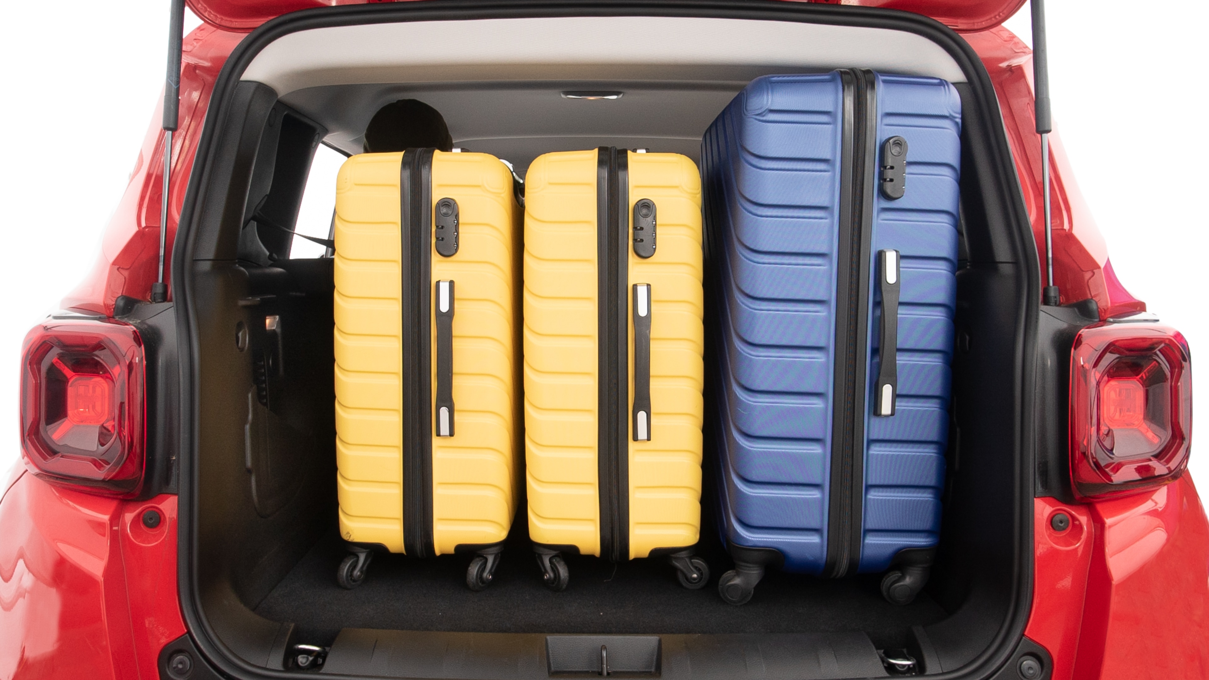 The trunk lid is open, showing full view of the trunk space. One extra large and two large suitcases are placed inside.